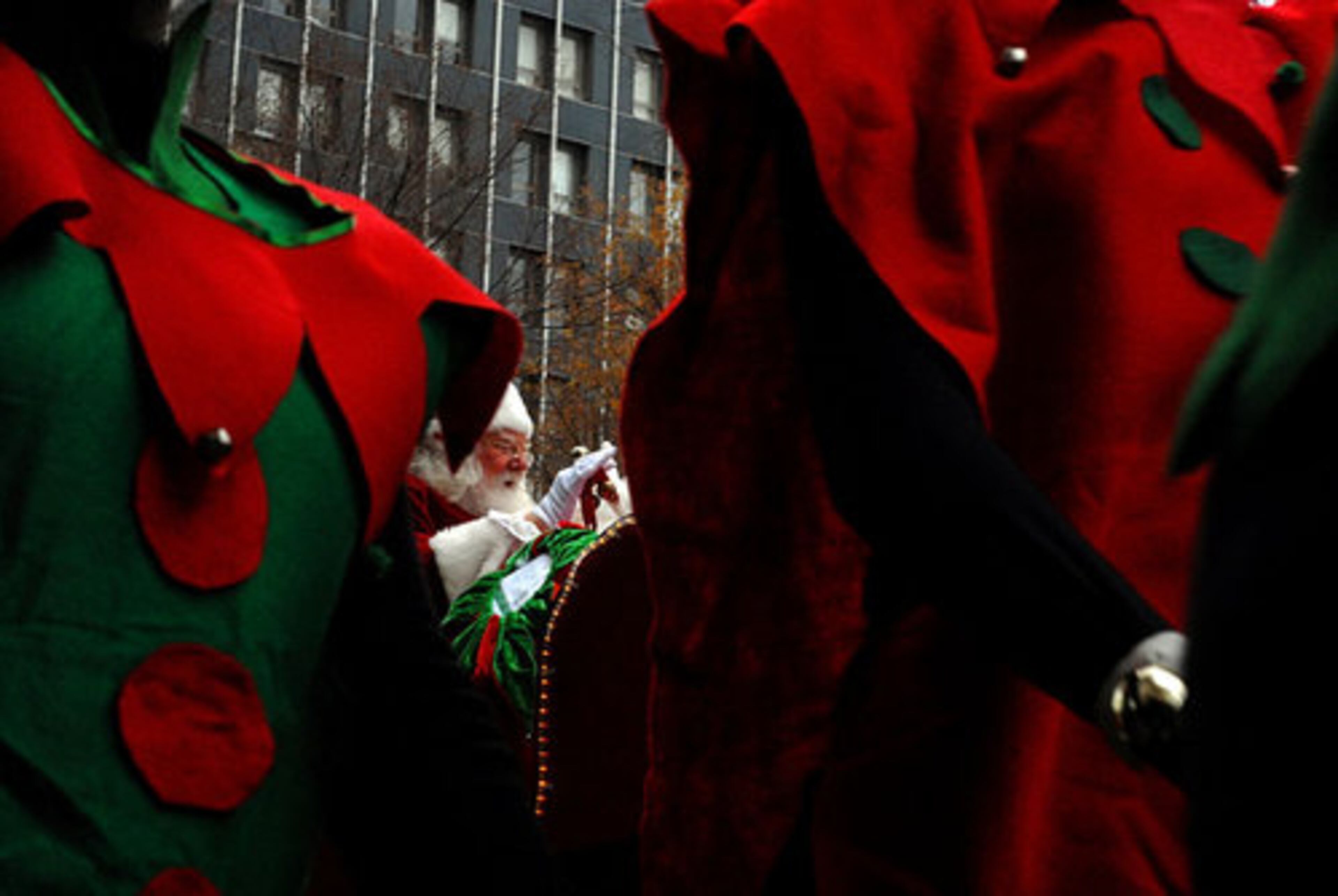 Santa Claus is seen through a gap in the Christmas elves.