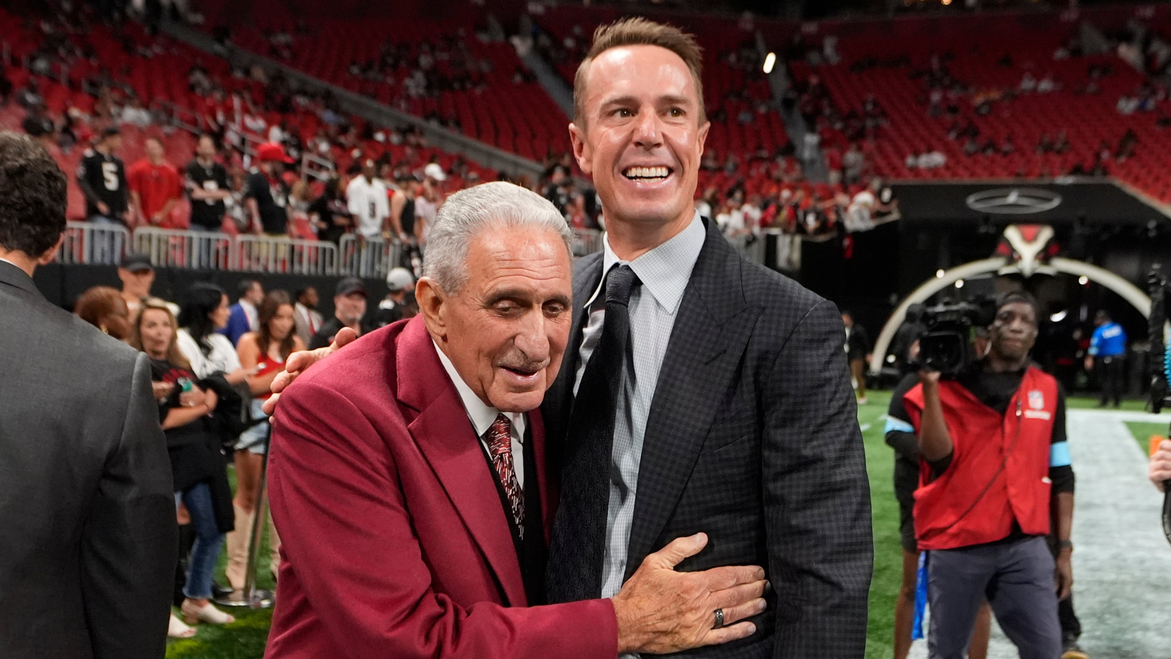 FILE - Atlanta Falcons owner Arthur Blank, left, talks to former quarterback Matt Ryan before an NFL football game against the Tampa Bay Buccaneers Oct. 3, 2024, in Atlanta. (AP Photo/John Bazemore, File)
