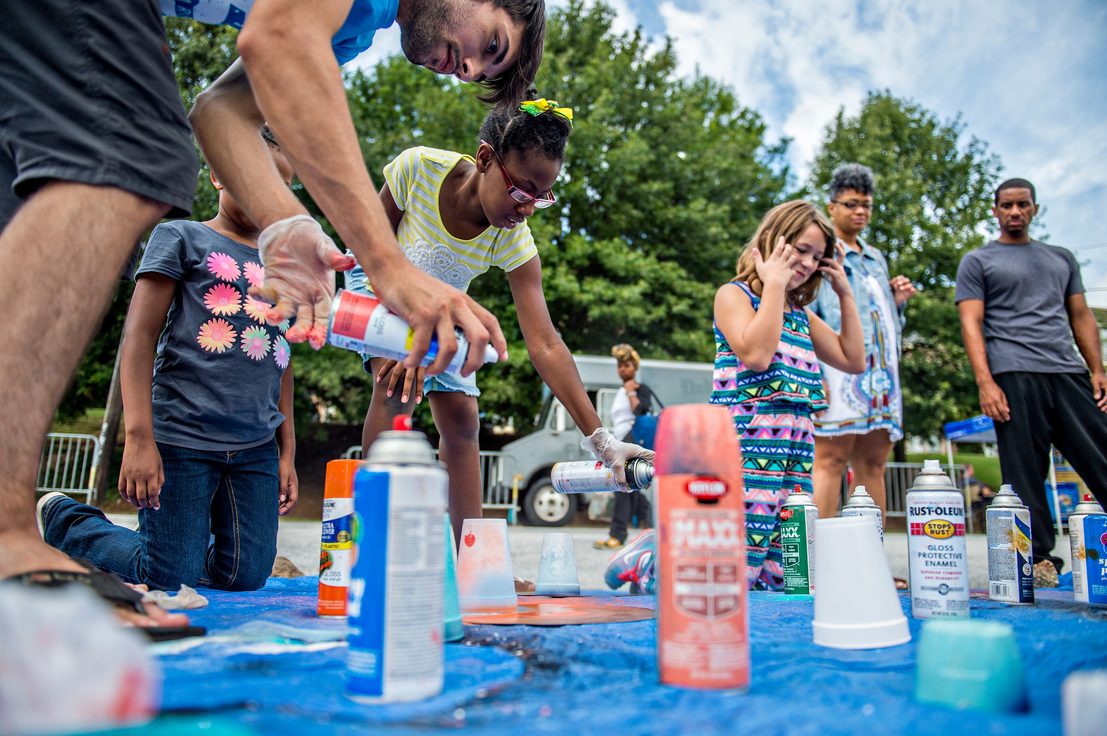 September 12, 2015 Atlanta - Ricci DeJesus (left), Yahkirah Manggium, and Kaitlin Green spray paint old records as they create art during the 5 Arts Fest in the Little Five Points neighborhood of Atlanta on Saturday, September 12, 2015. In its second year, the 5 Arts Fest brings together the community to participate in literary, visual, recording and performing arts as well as arts and crafts projects. JONATHAN PHILLIPS / SPECIAL