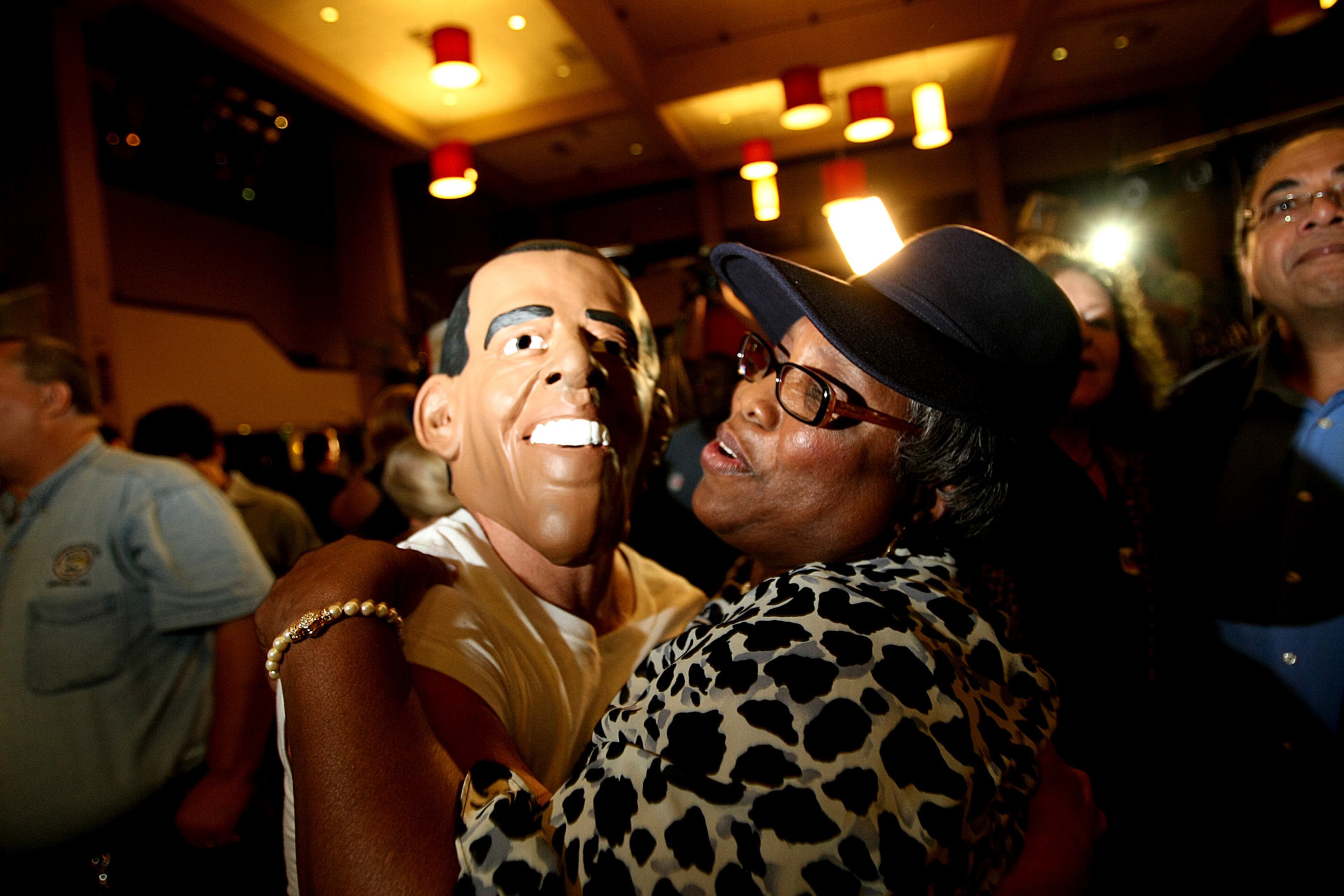 West Palm Beach -- Doug Savoca, of Cleveland, Ohio, left, with Obama mask, celebrates with Mary Brabham, right, of Riviera Beach, after President Barack Obama is announced with 270 Electoral Votes at the Democratic Party election night celebration at the Embassy Suites in West Palm Beach on Tuesday.(Gary Coronado/The Palm Beach Post)