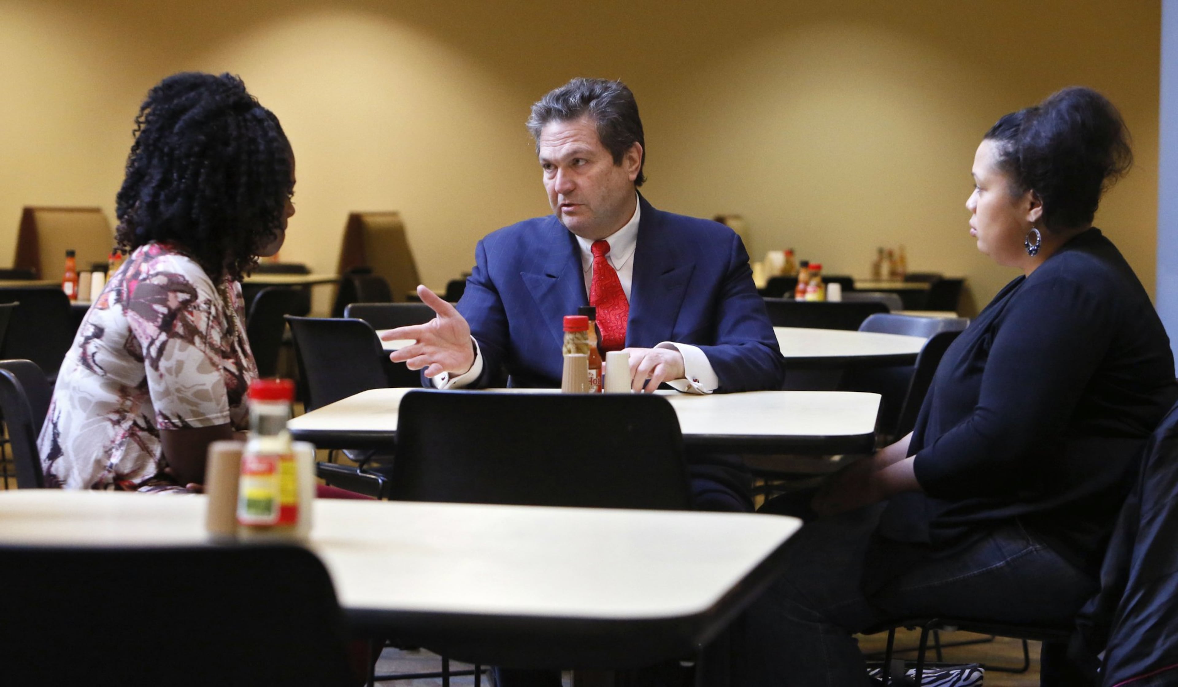 Rick Jackson meets with Brittany Jean (right) and Crystal Williams, two former foster kids, at the Sloppy Floyd Building. Jackson grew up in Techwood Homes, but now lives in a 47,000-square-foot mansion in Forsyth County. (Bob Andres/AJC file)