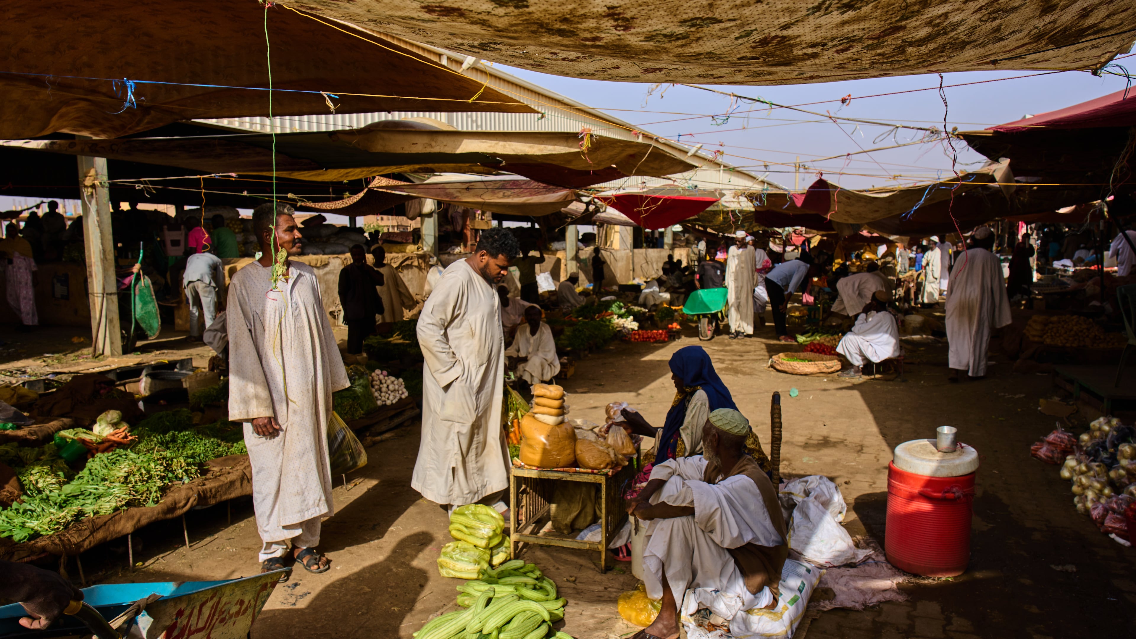 Customers buy vegetables at a market in Omdurman, on the outskirts of Khartoum, Sudan, Sunday, April 26, 2026. (AP Photo/Bernat Armangue)