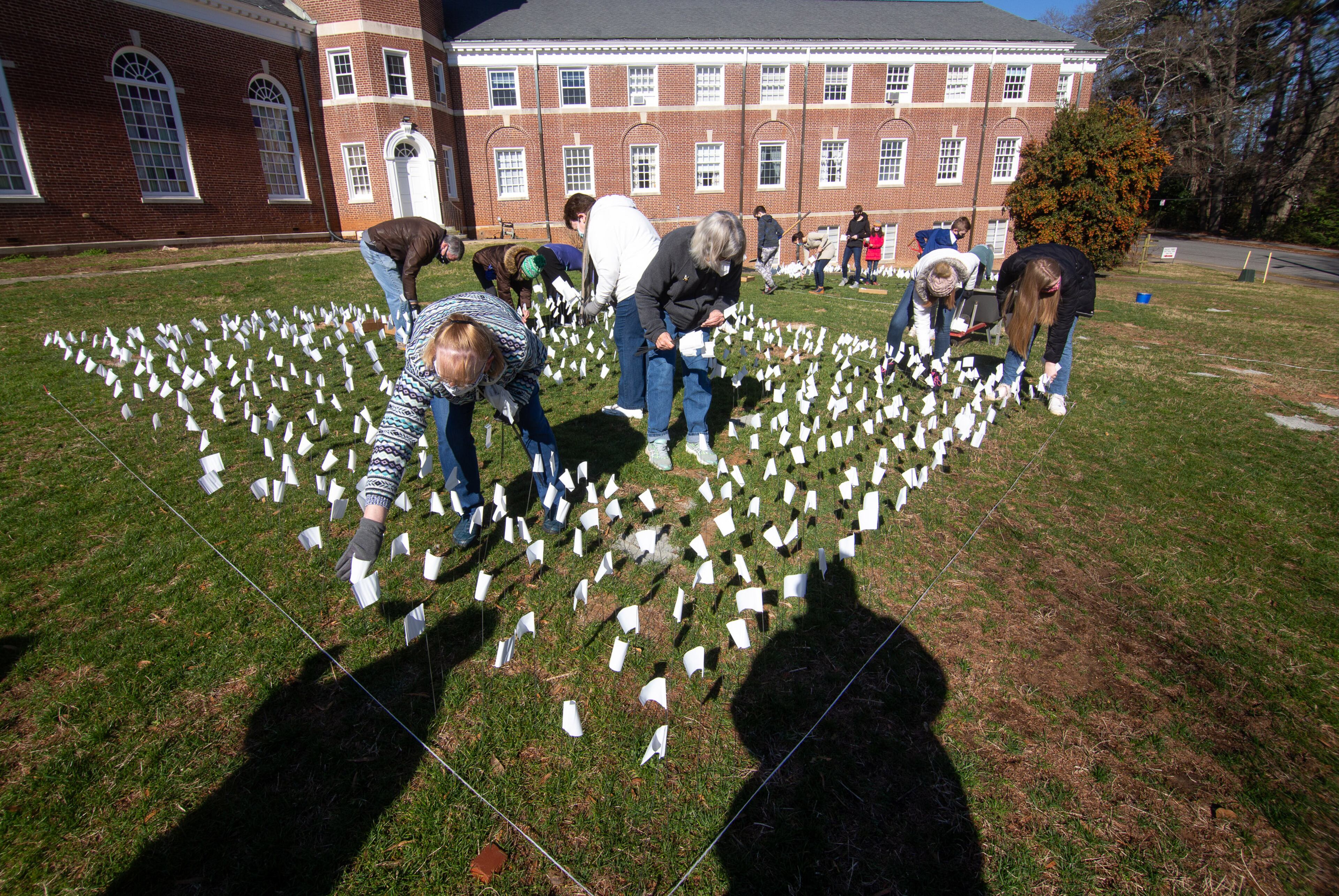 Volunteers plants some of the 15,000 flags on the lawn of First Christian Church of Decatur on Saturday, February 20, 2021. The flags represent the number of COVID-19 deaths in Georgia, and the effort aims to raise awareness about the toll of the coronavirus. (Photo: Steve Schaefer for The Atlanta Journal-Constitution)