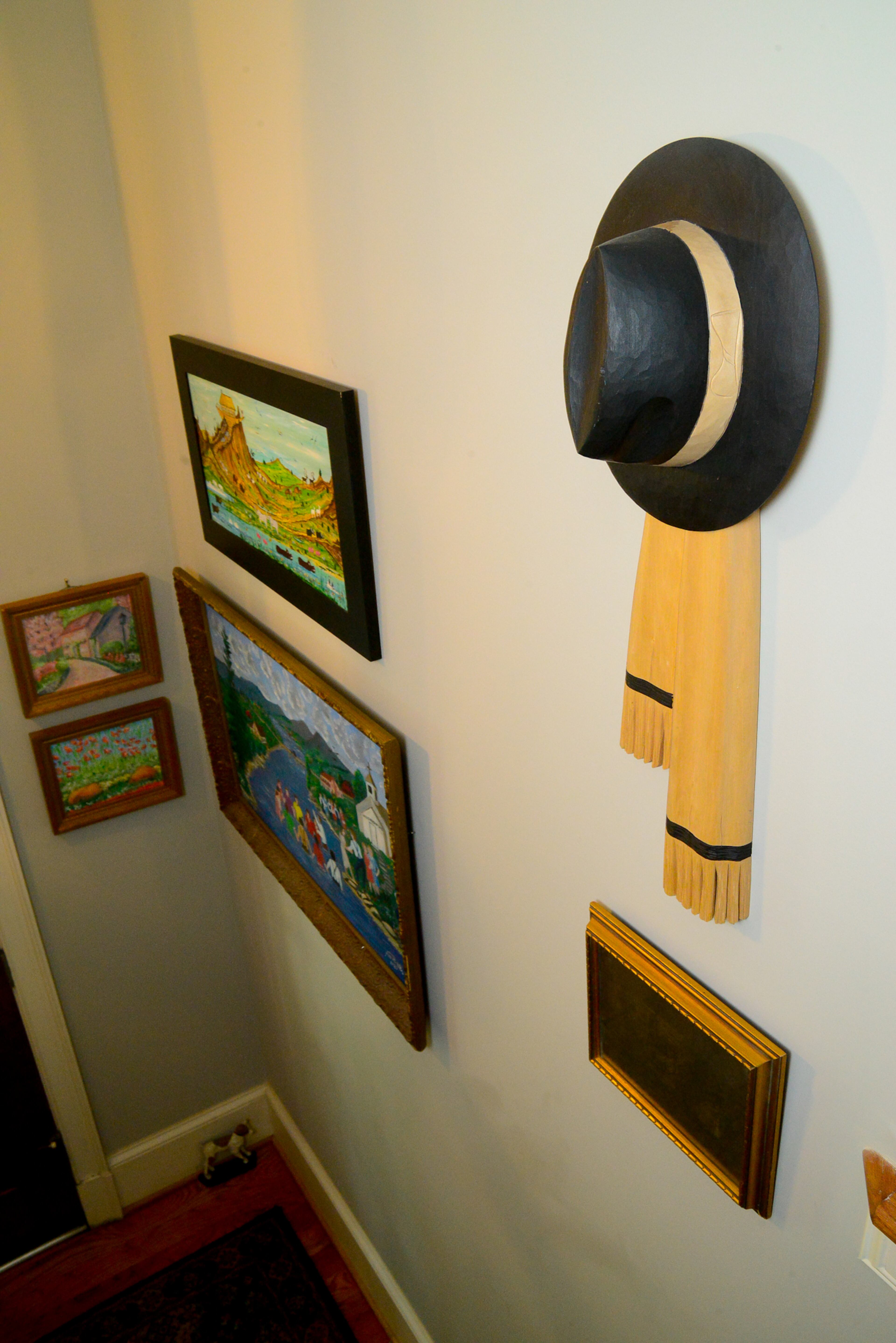 The hallways boast the homeowners' extensive collection of folk art and painting by family members, as well as unusual items. The wooden carving of a hat and scarf was a piece they found while visiting Quebec.