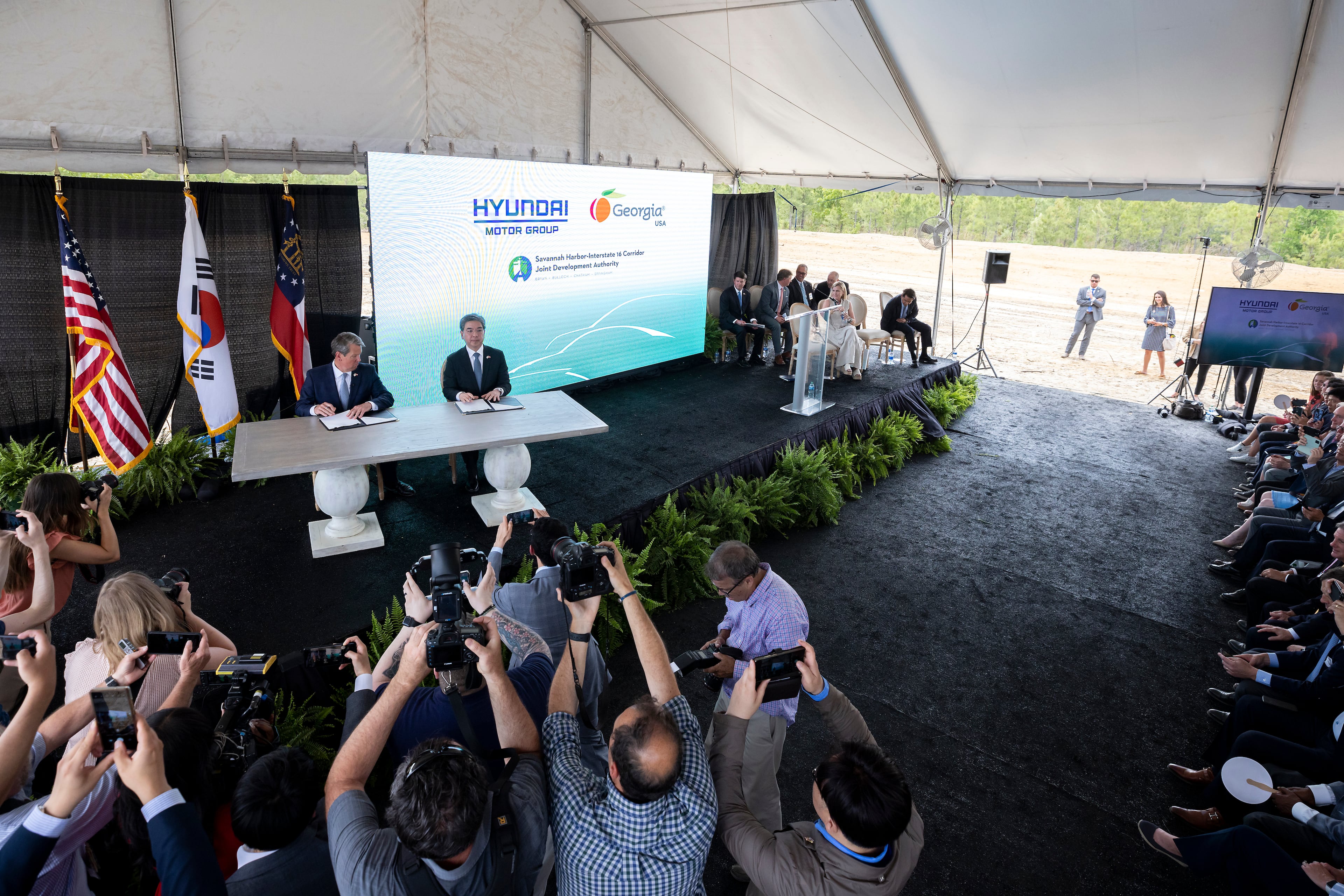 ELLABELL, GEORGIA - MAY 20, 2022: Governor Brian P. Kemp, center left, and
Hyundai Motor Group President and CEO Jae Hoon Chang, center right, sign a ceremonial document at the announcement that the South Korean automotive giant is building an electric vehicle plant in Ellabell, Ga. Hyundai plans to build a multi-billion-dollar electric vehicle assembly and battery plant outside of Savannah that eventually could employ about 8,100 workers. (AJC Photo/Stephen B. Morton)