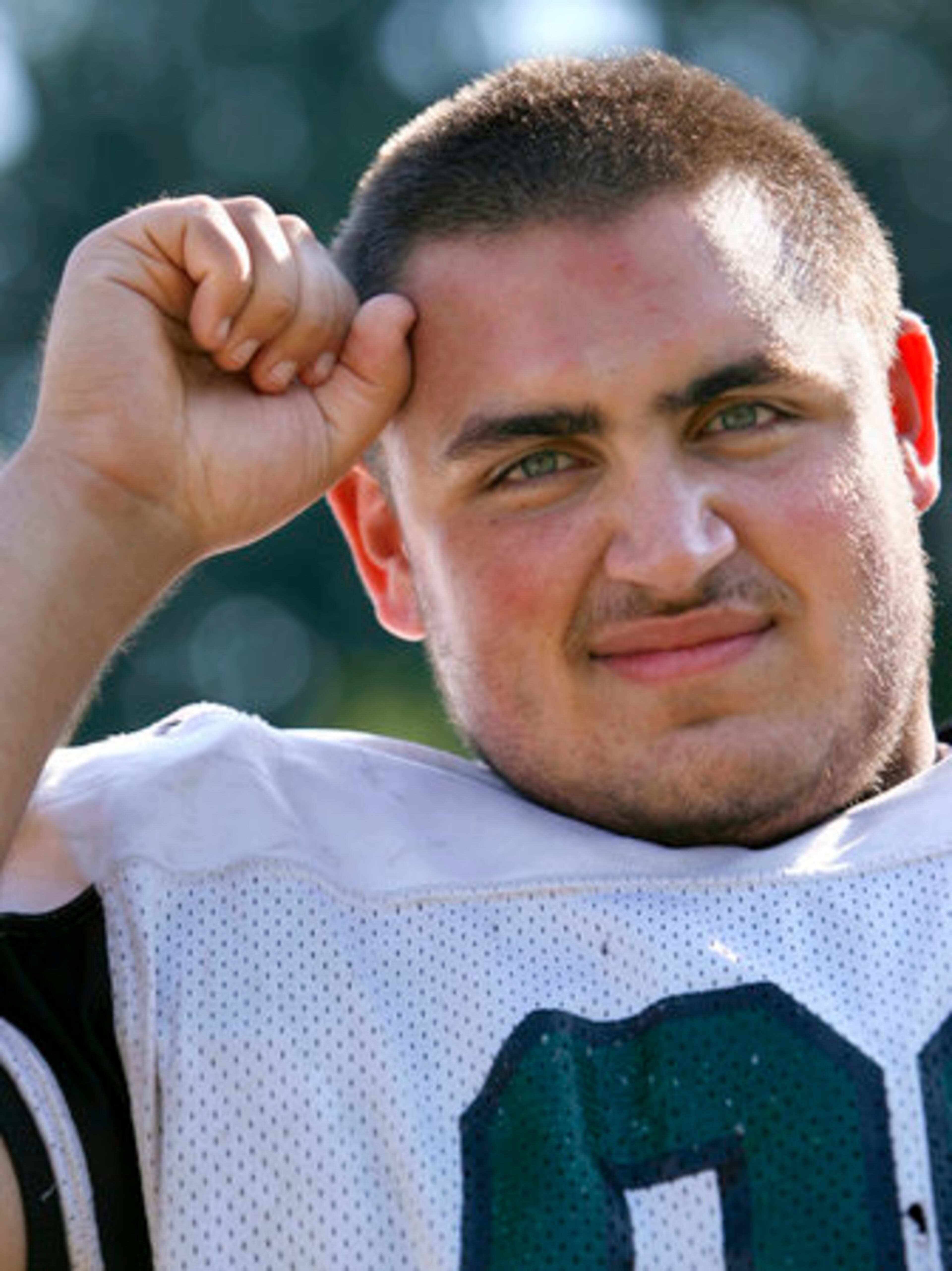 Kennesaw Mountain senior defensive lineman Scotty Frieman watches as interpreter Rose Crews translates his coach's instructions. Frieman is deaf and has been playing football for four years, "I love football," he says.
