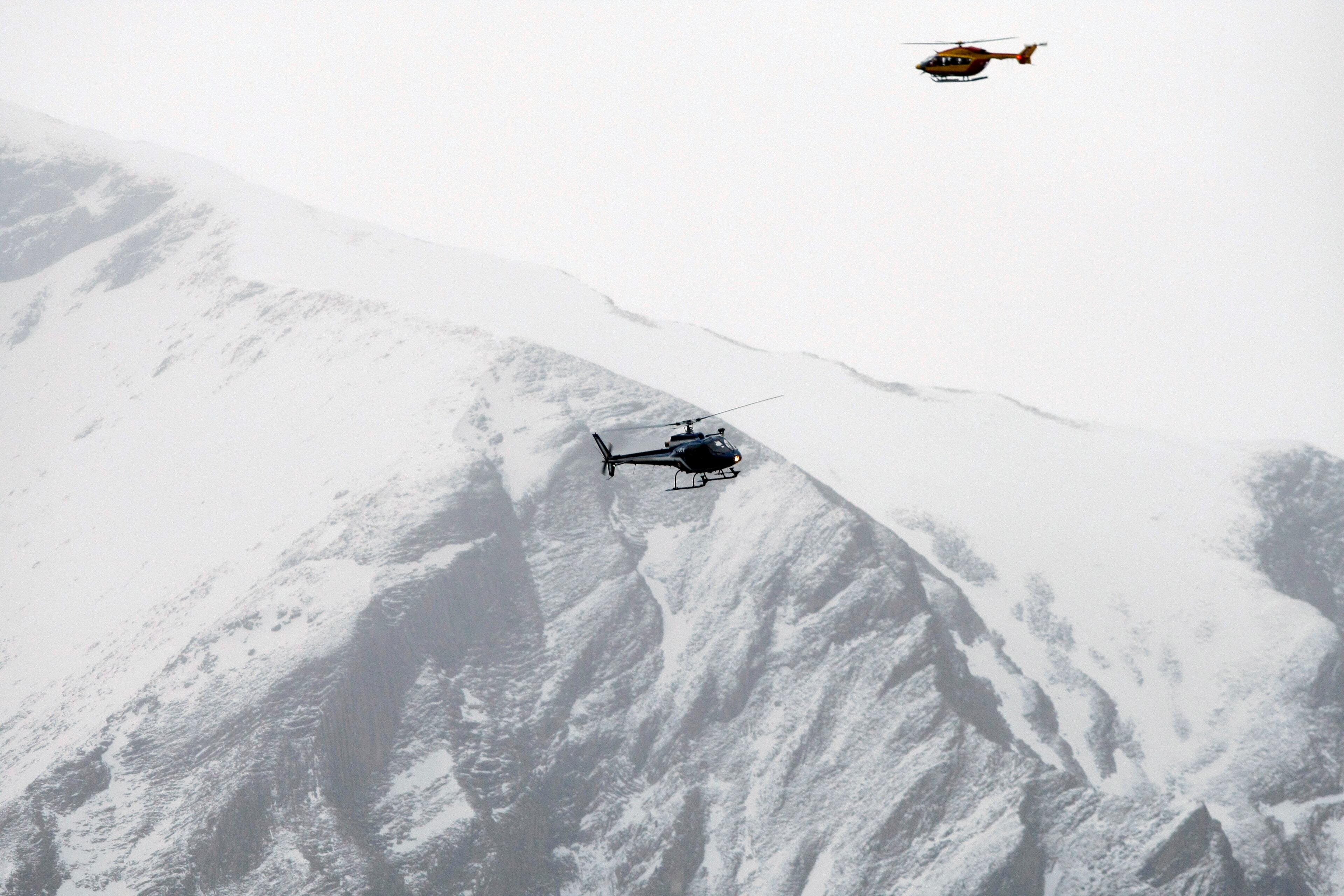Rescue helicopters fly over the mountainside near Seyne-les-Alpes, French Alps, Tuesday, March 24, 2015. A Germanwings passenger jet carrying at least 150 people crashed Tuesday in a snowy, remote section of the French Alps, sounding like an avalanche as it scattered pulverized debris across the mountain. (AP Photo/Claude Paris)
