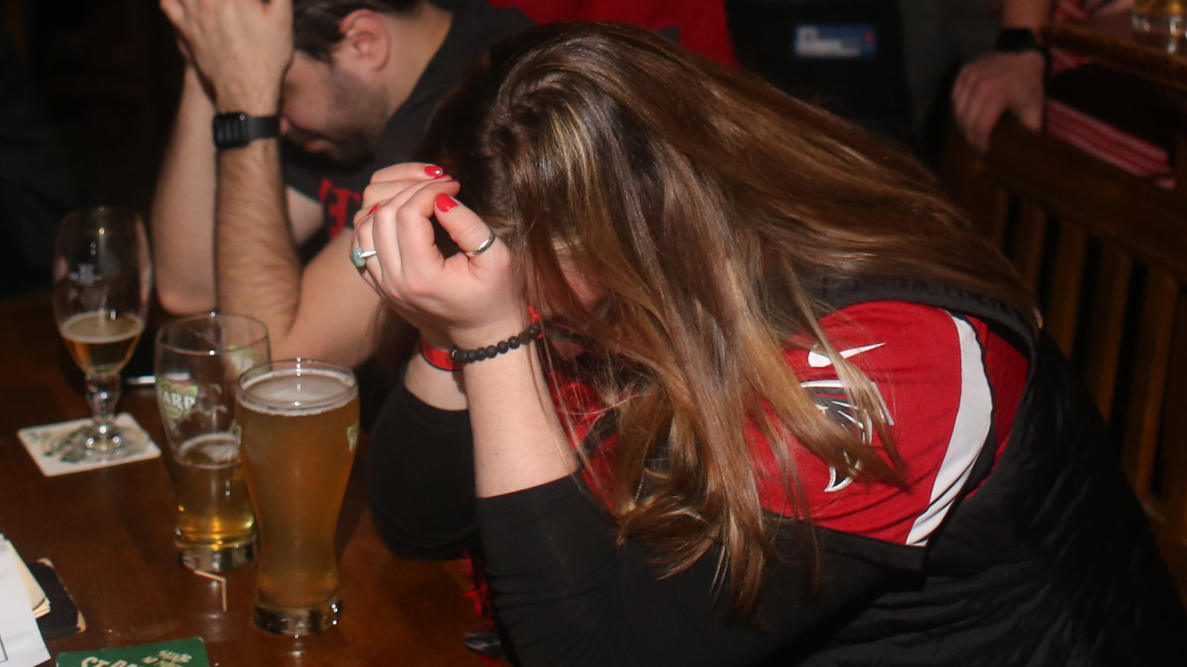 Fans put their heads down as the Atlanta Falcons gave up Super Bowl LI to the New England Patriots on Sunday. (Henry Taylor / henry.taylor@ajc.com)