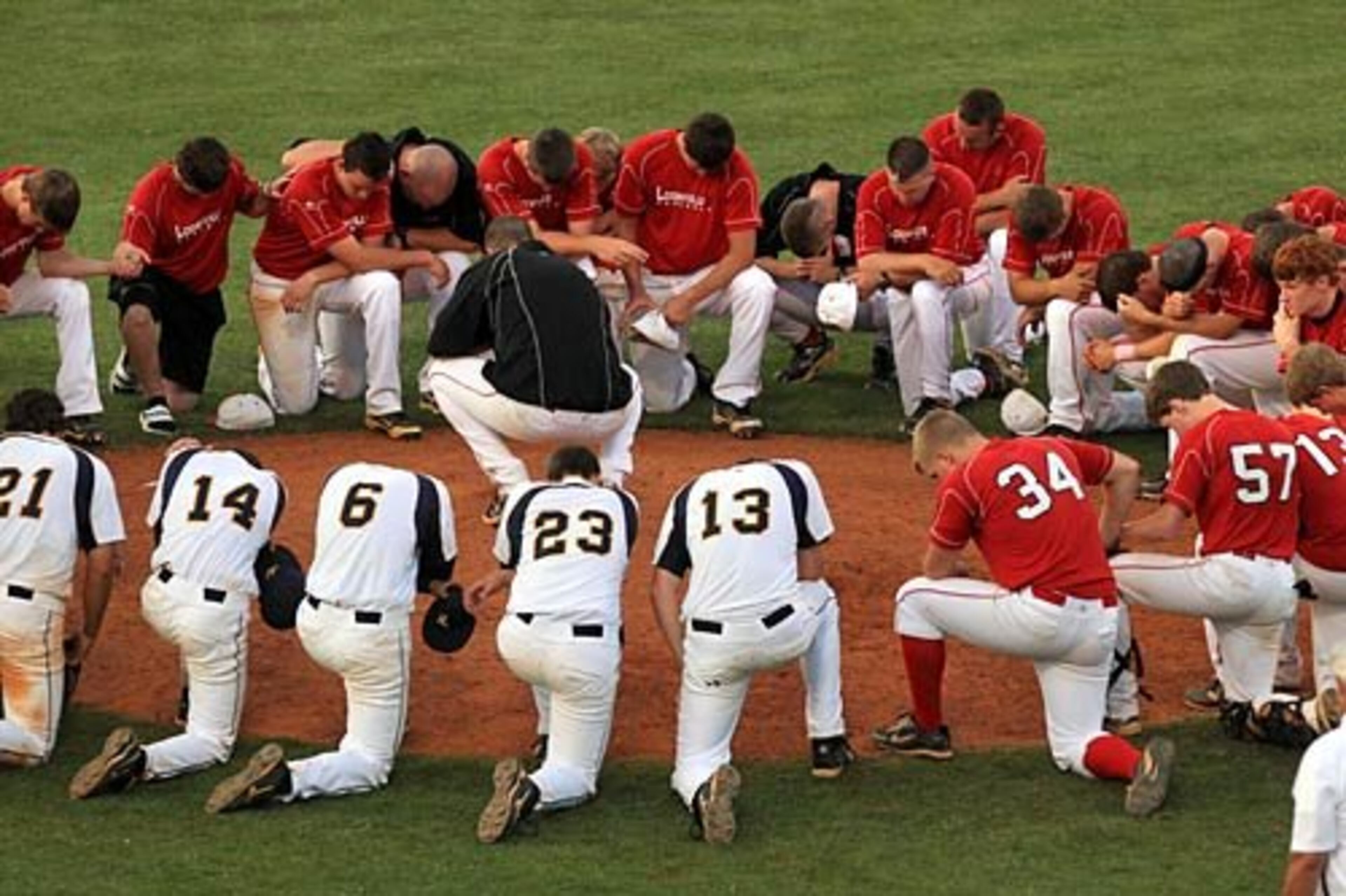 Good sports: The Loganville Red Devils gather with the Marist War Eagles to end the game with a prayer at the pitcher's mound following a 13-6 victory by Marist to advance in the Class AAAA semifinal series.