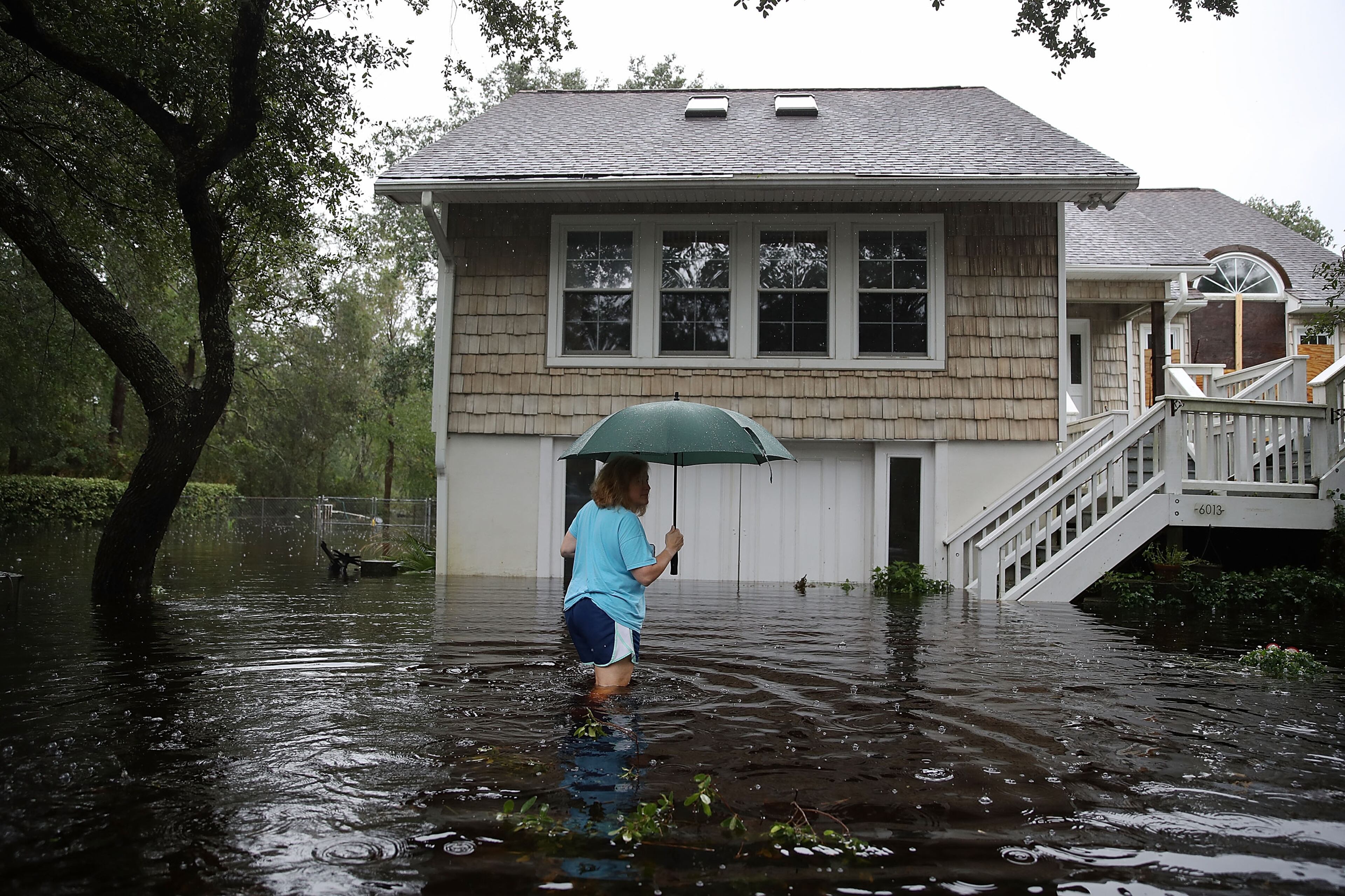 SOUTHPORT, NC - SEPTEMBER 15: Kim Adams makes her way to her home that is surrounded by flood waters after Hurricane Florence passed through the area on September 15, 2018 in Southport, North Carolina. Hurricane Florence hit the North Carolina and South Carolina coastline bringing high winds and rain. (Photo by Joe Raedle/Getty Images)