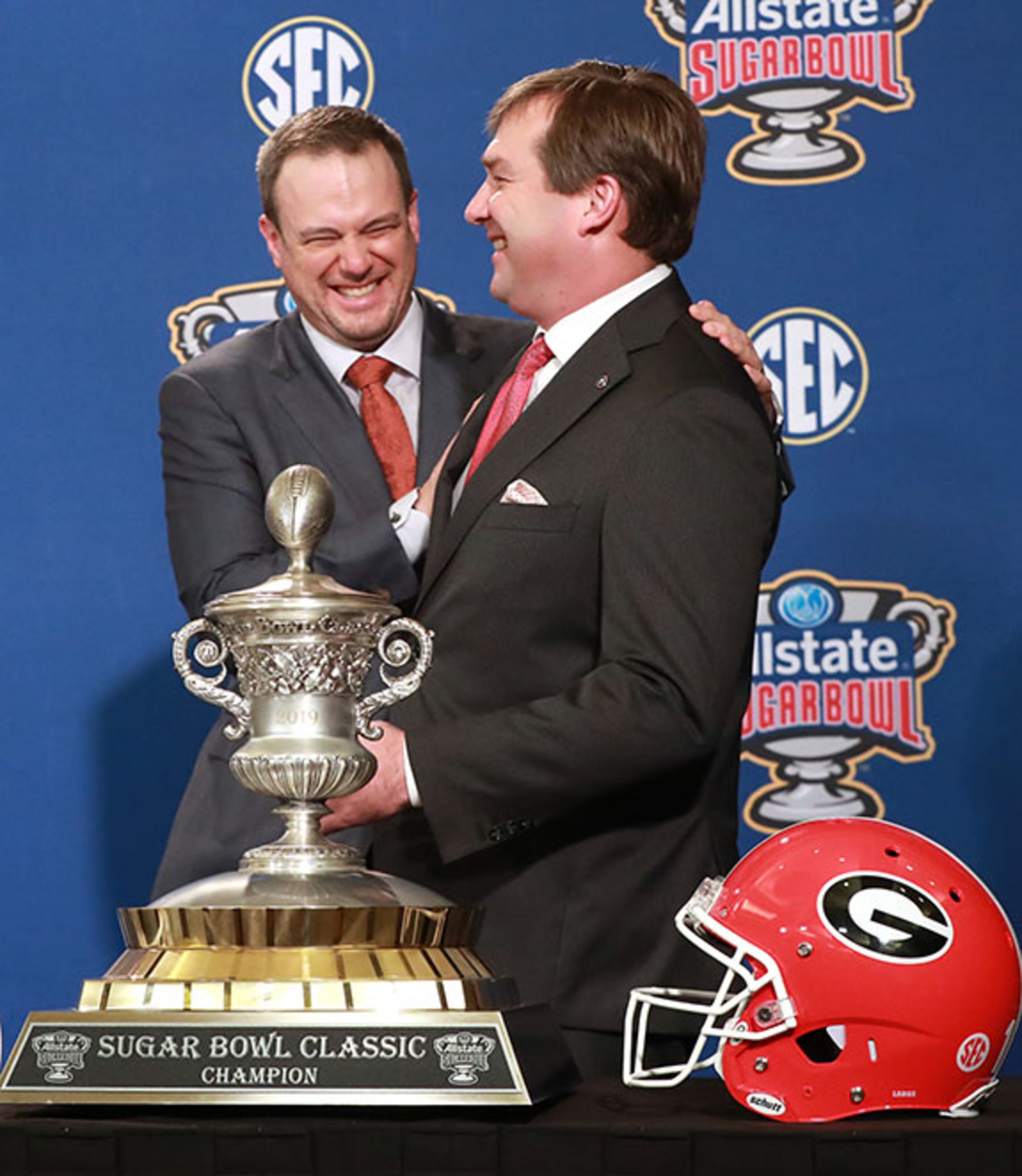 Georgia head coach Kirby Smart and Texas head coach Tom Herman share a laugh during their photo opportunity with the Sugar Bowl trophy at the head coaches press conference on Monday, Dec. 31, 2018, in New Orleans.