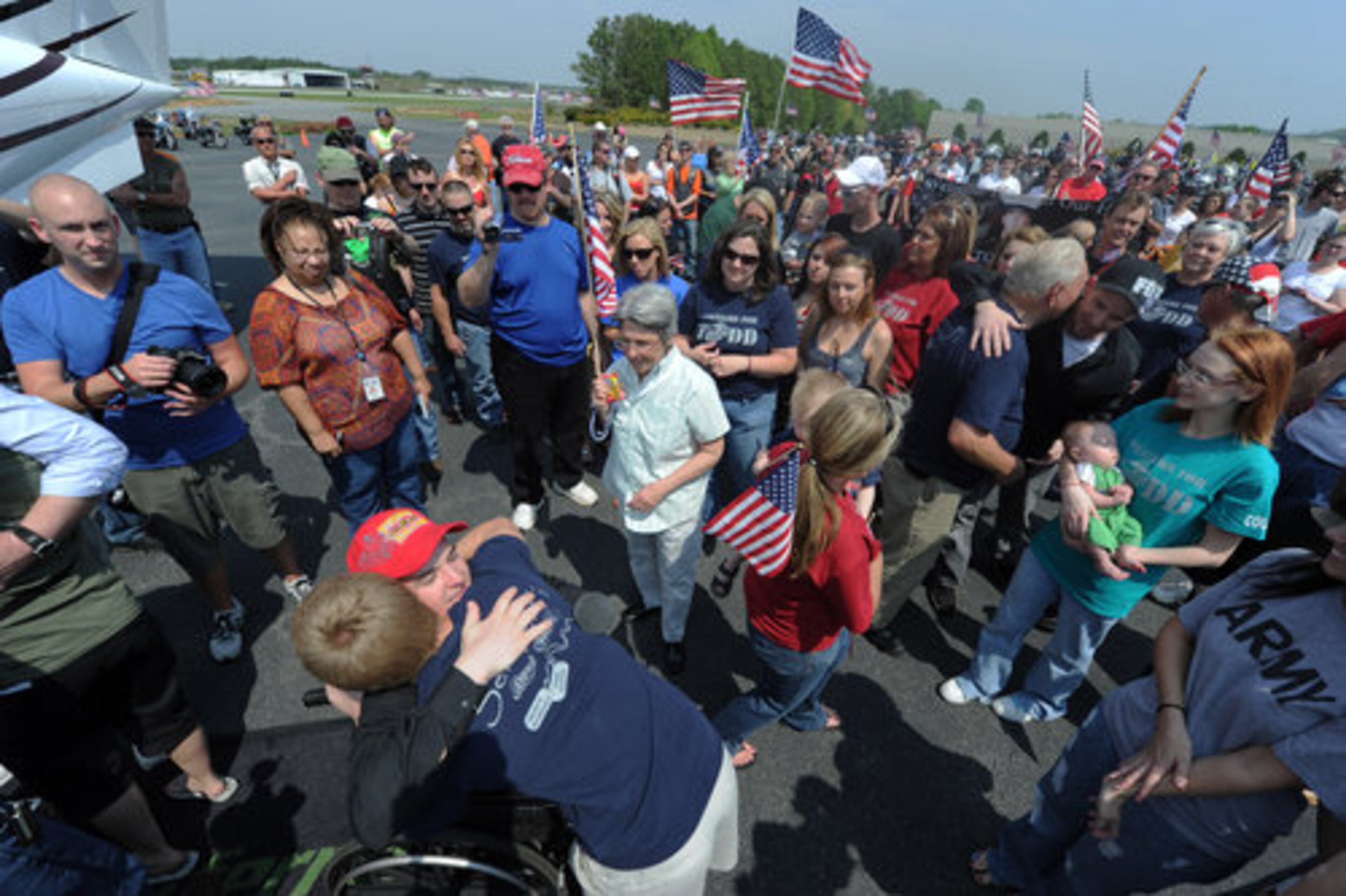 Marine Cpl. Todd Simpson Love, who lost both legs and part of an arm fighting in Afghanistan, receives a hug after getting off a plane at McCollum Field on Saturday. More than 500 people greeted the plane.