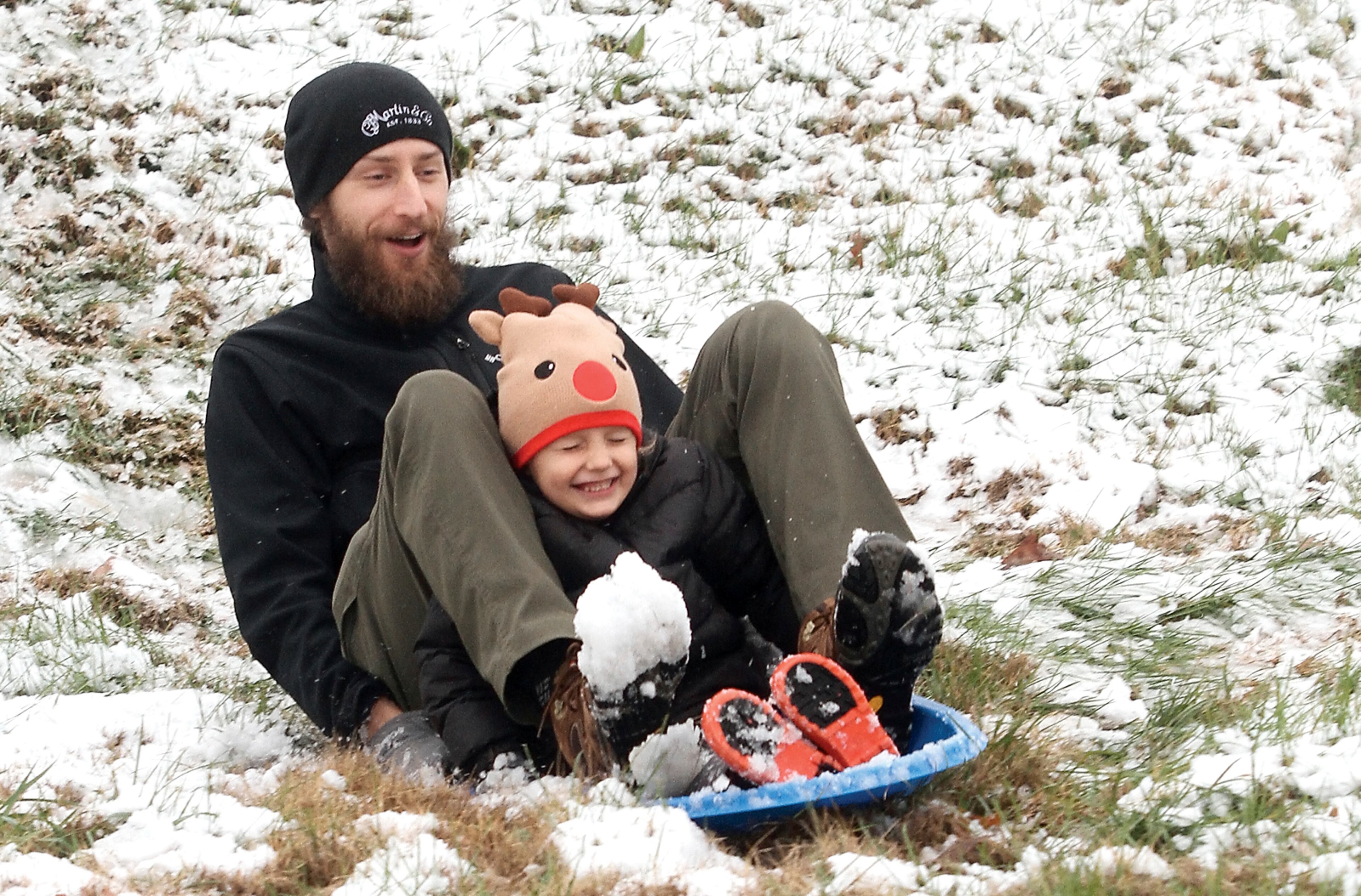 Luke Dunnewold and son Judah enjoy a sled ride down the hill at Foothills Mall in Maryville, Tennessee Sunday, December 9, 2018 after the first snow of the season. (Tom Sherlin/The Daily Times via AP)