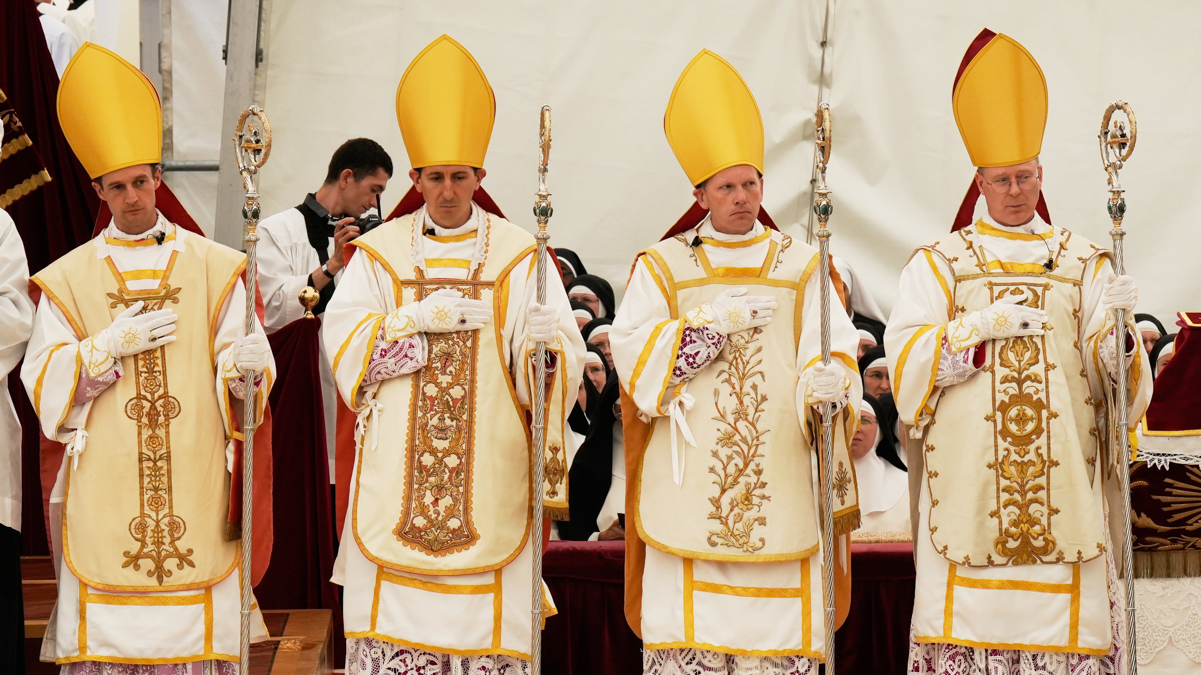 Newly consecrated Bishops, from left, Marc Hanappier, Michel Poinsinet de Sivry, Michael Goldade and Pascal Schreiber wearing their miters and holding their pastoral staffs, stand at the end of their consecration ceremony in a tent set up outside the Society of St. Pius X seminary in Econe, Switzerland, Wednesday, July 1, 2026. (AP Photo/Baz Ratner)