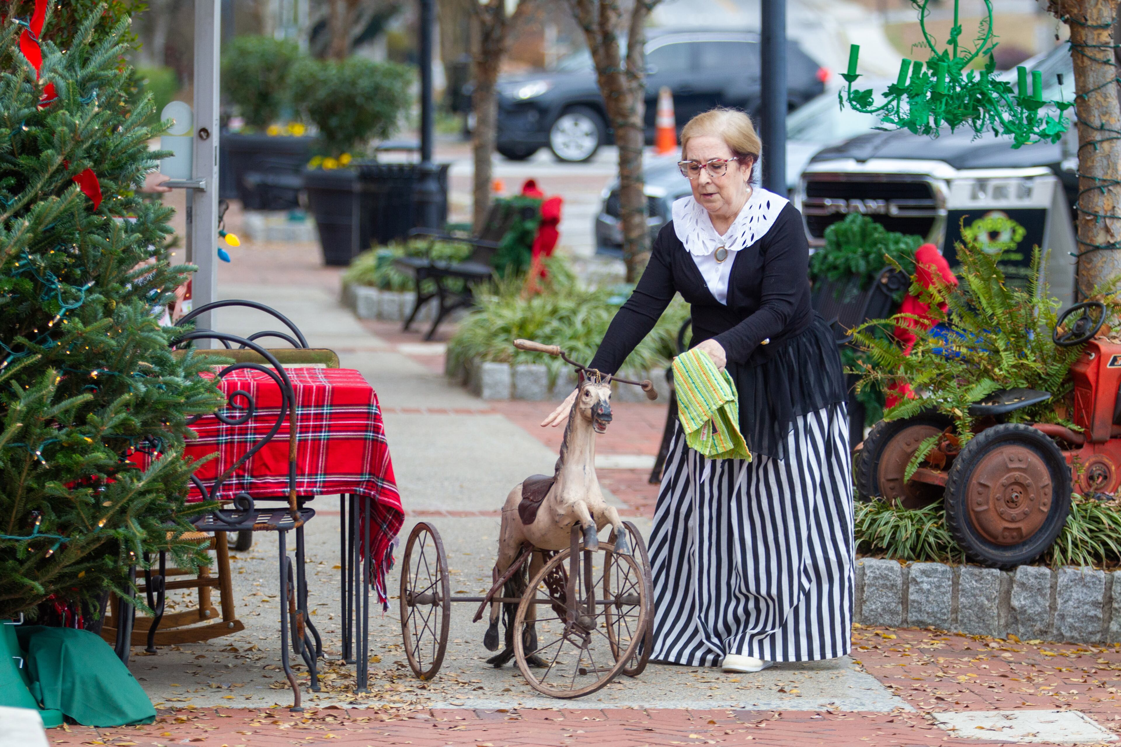 Mary Dowdy sets up a table outside the Antique Traditions shop during the Christmas Village weekend event in historic downtown Norcross on Sunday, December 5, 2021. (Photo: Steve Schaefer for The Atlanta Journal-Constitution)