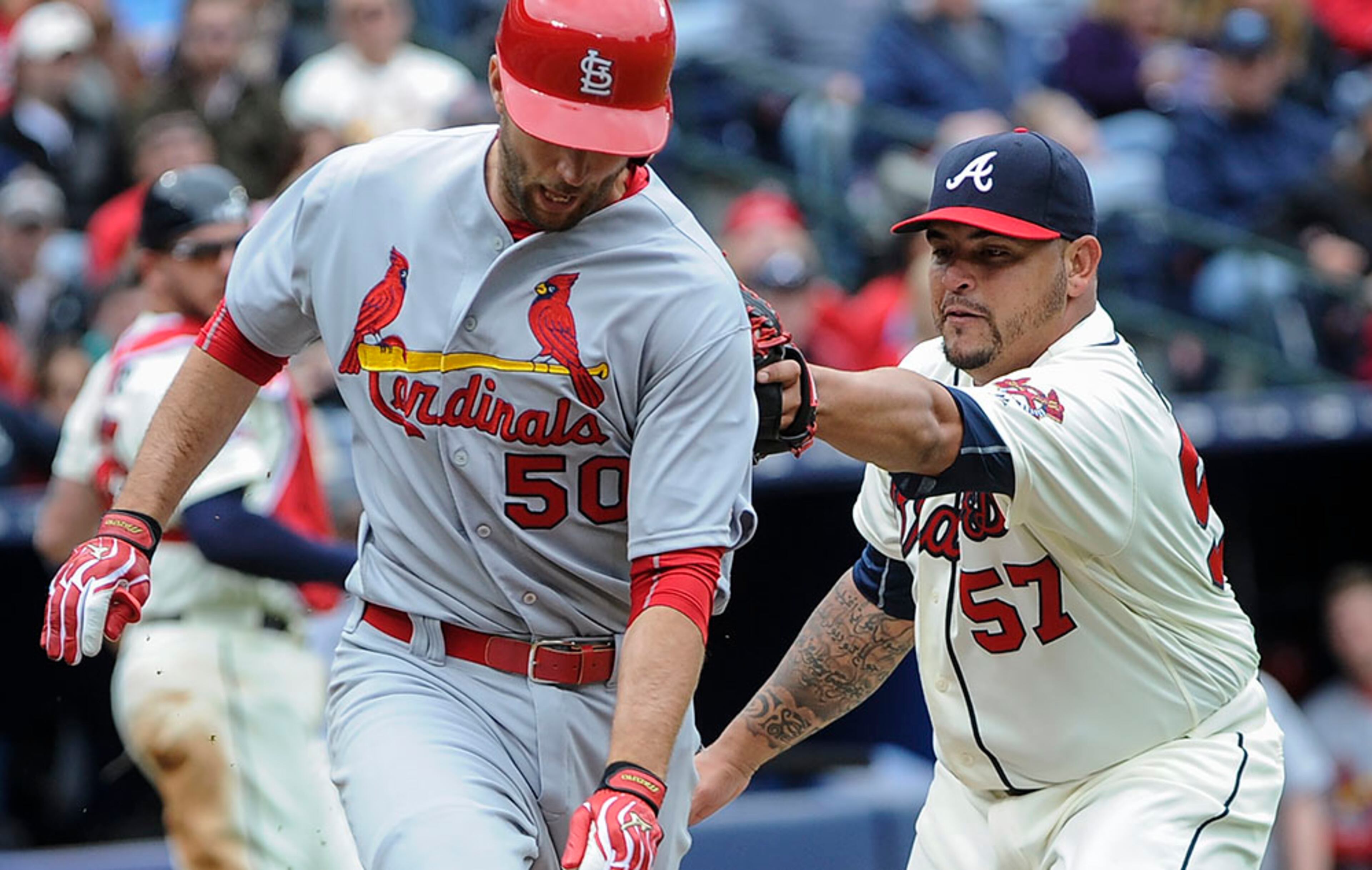 Atlanta Braves pitcher Williams Perez (57) tags out St. Louis Cardinals' Adam Wainwright (50) along the first base line after a bunt during the third inning Sunday, April 10, 2016, in Atlanta.