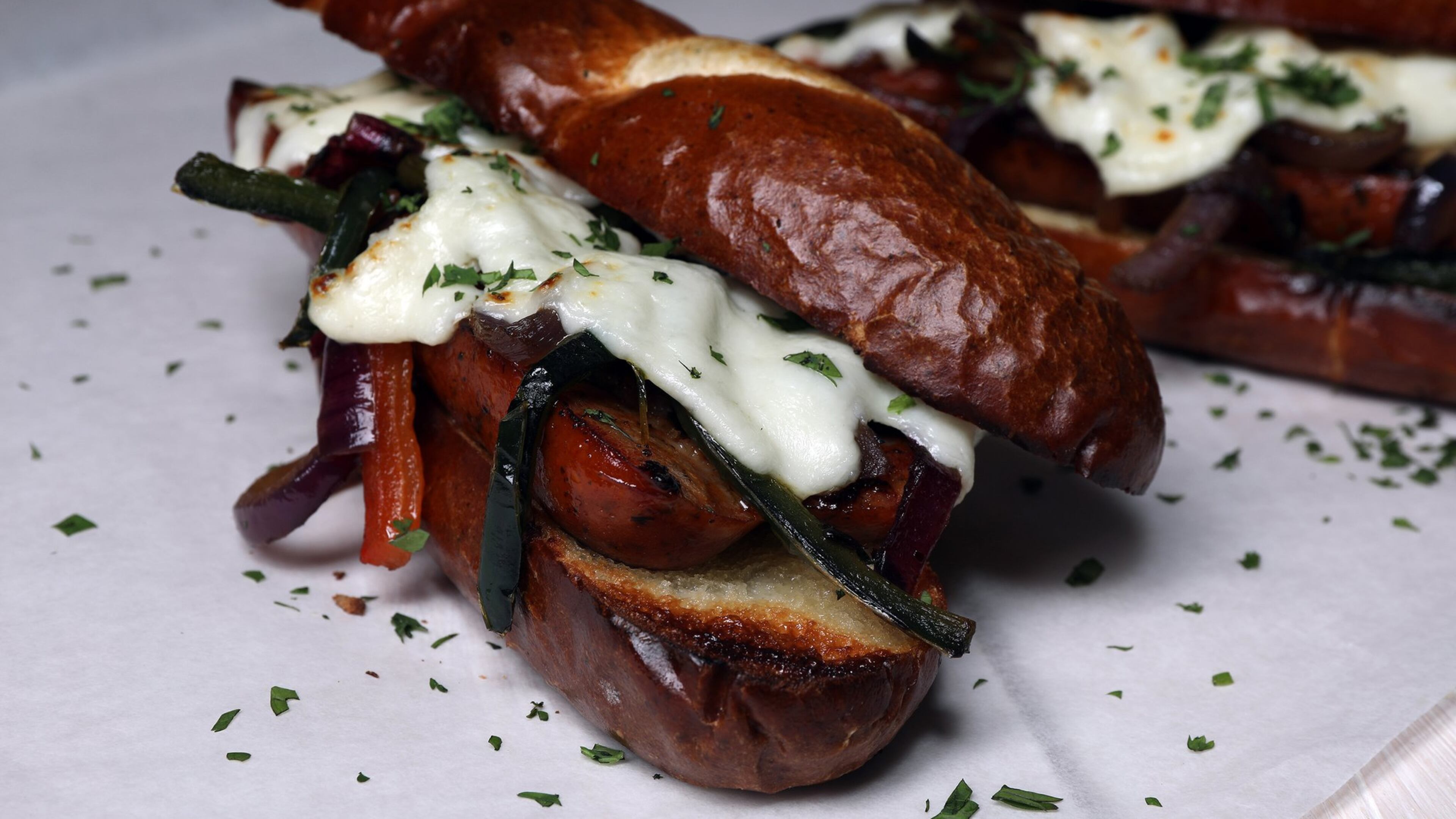 A mix of sauteed peppers and onions crowns sausage and cheese sandwiches on toasted rolls. (Mark Graham/food styling) (Terrence Antonio James/Chicago Tribune/TNS)