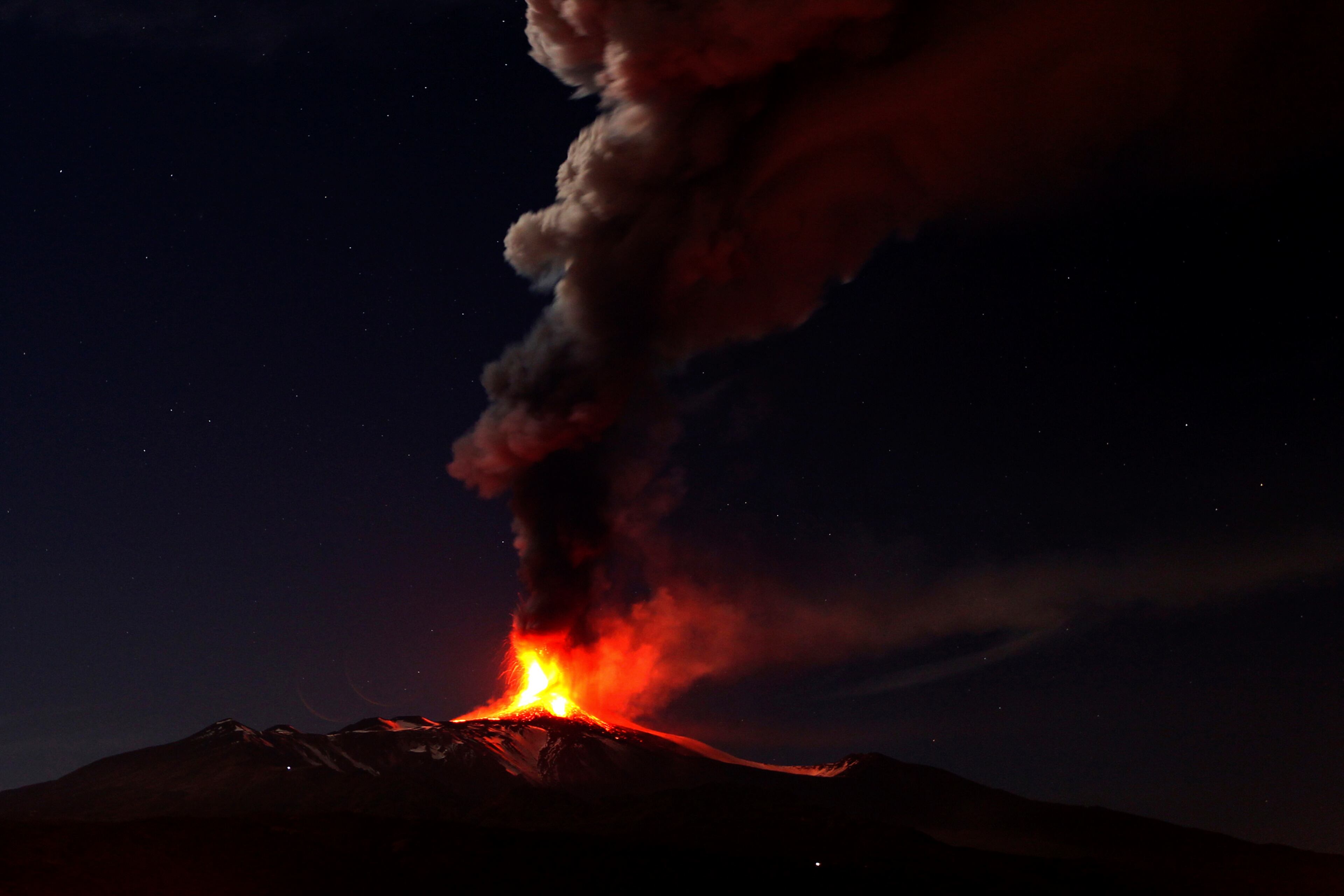 In this photo taken on Saturday, Nov. 16, 2013, Mt. Etna, Europe's most active volcano, spews lava during an eruption as seen from Acireale, near the Sicilian town of Catania, Italy. (AP Photo/Carmelo Imbesi)