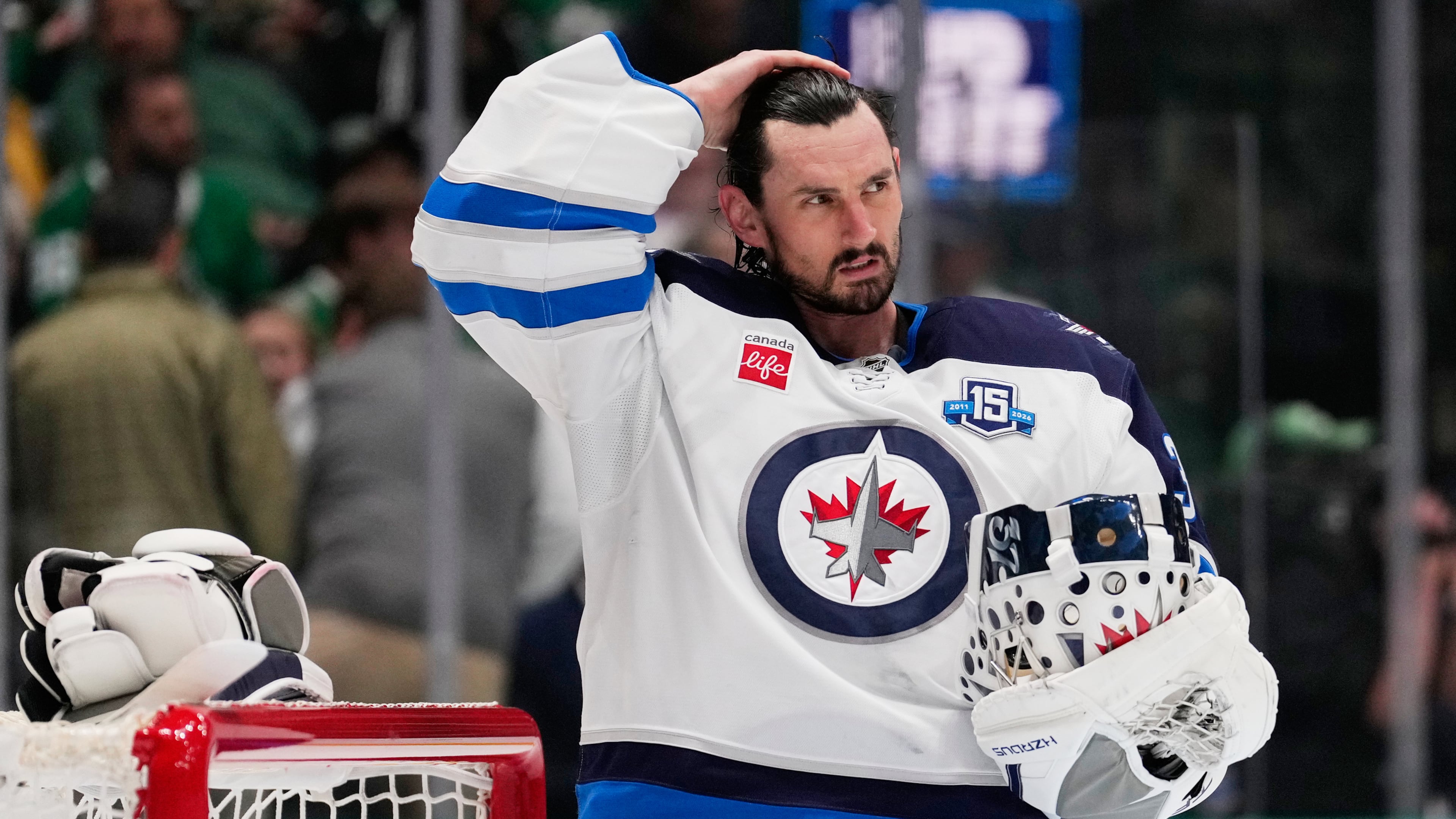 FILE - Winnipeg Jets goaltender Connor Hellebuyck stands by the net during a time out from play against the Dallas Stars in the first period of an NHL hockey game, April 2, 2026, in Dallas. (AP Photo/Tony Gutierrez, File)