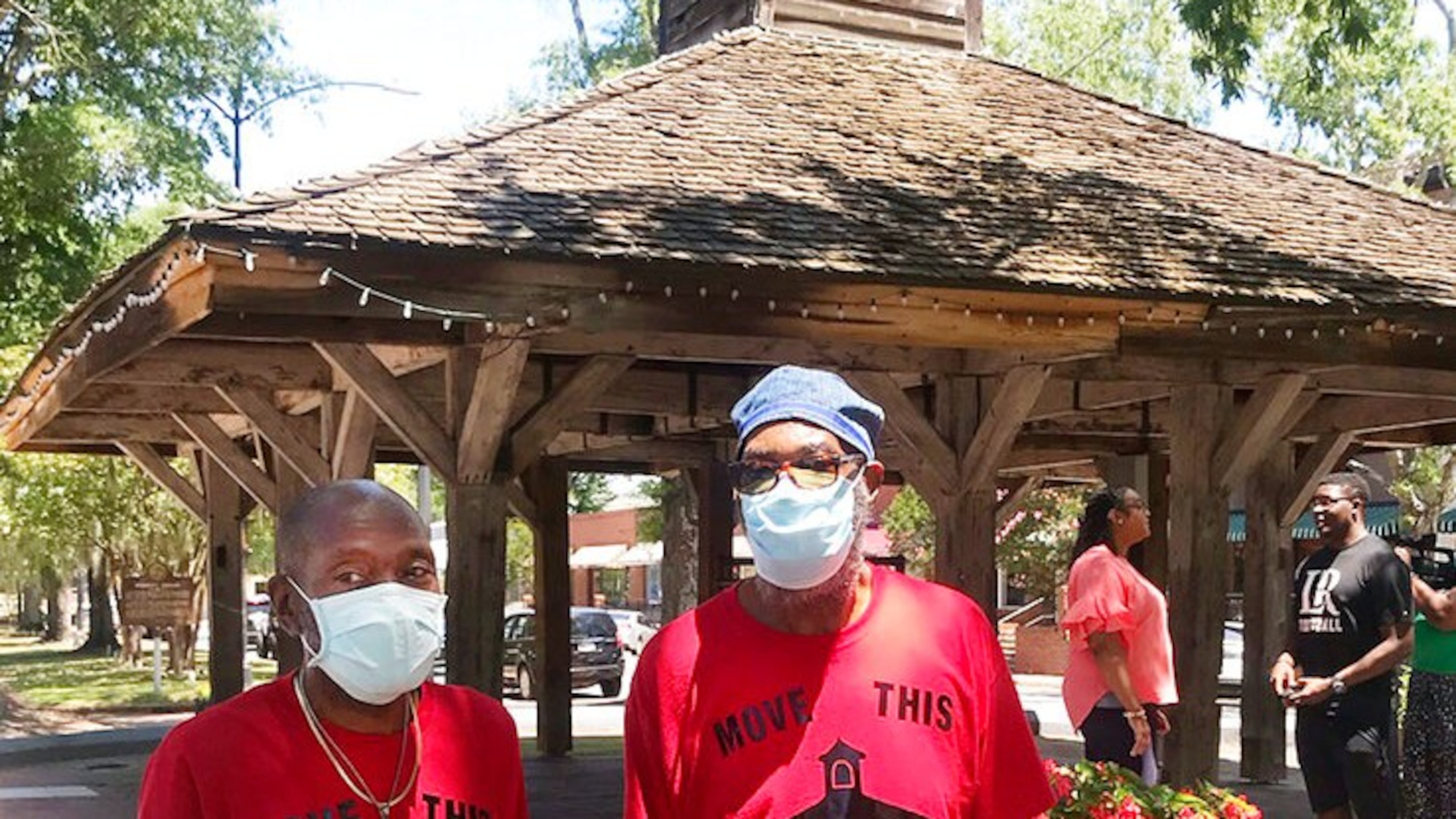 Charles and Eugene Washington, an older generation of freedom fighters, stand in the foreground as Nikki Tarver and Myles Jackson, a younger generation can be seen talking in the background on June 30, 2020, in Louisville, Ga. All four have voiced their desires to see the market in Louisville where slaves were once sold removed from its present location. (Parish Howard/The Augusta Chronicle via AP)