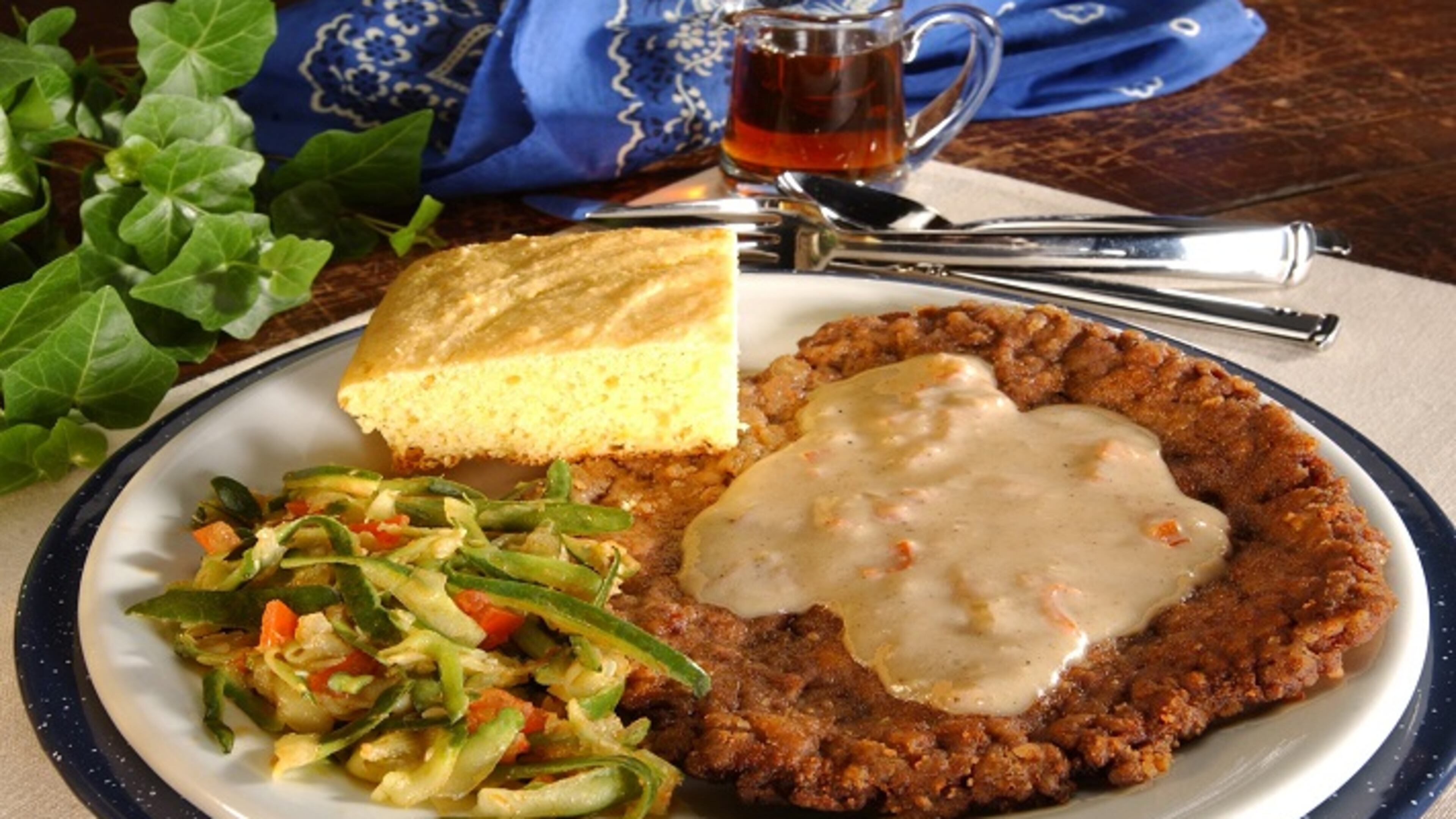 Chicken-fried steak with tomato- and onion-studded pan gravy. (James F. Quinn/Chicago Tribune/TNS)