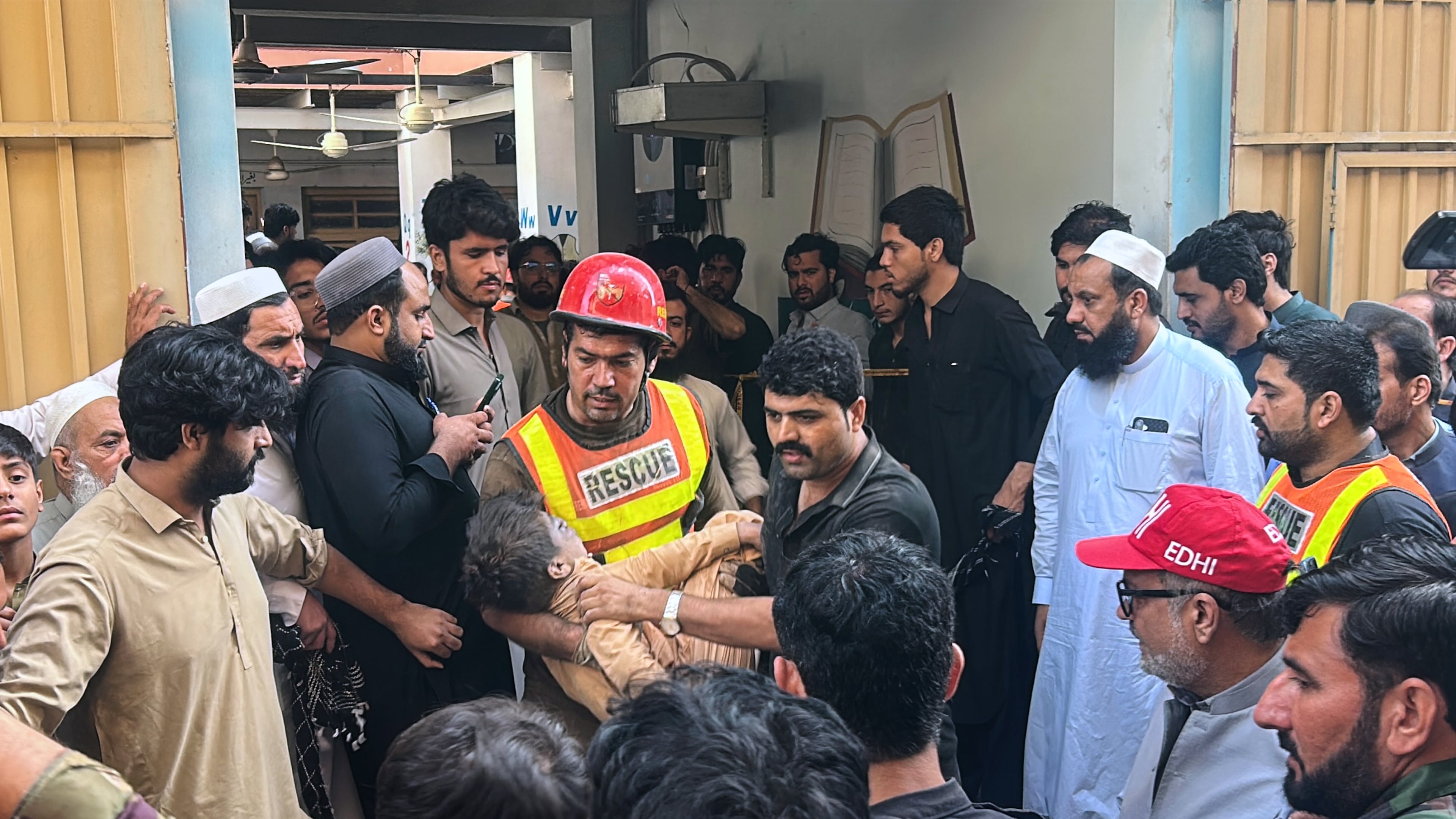 A rescue worker carries an injured child after rescuing him from the rubble of a roof collapse at a private school, in Peshawar, Pakistan, Thursday, Oct. 15, 2026. (AP Photo/Arif Khan)