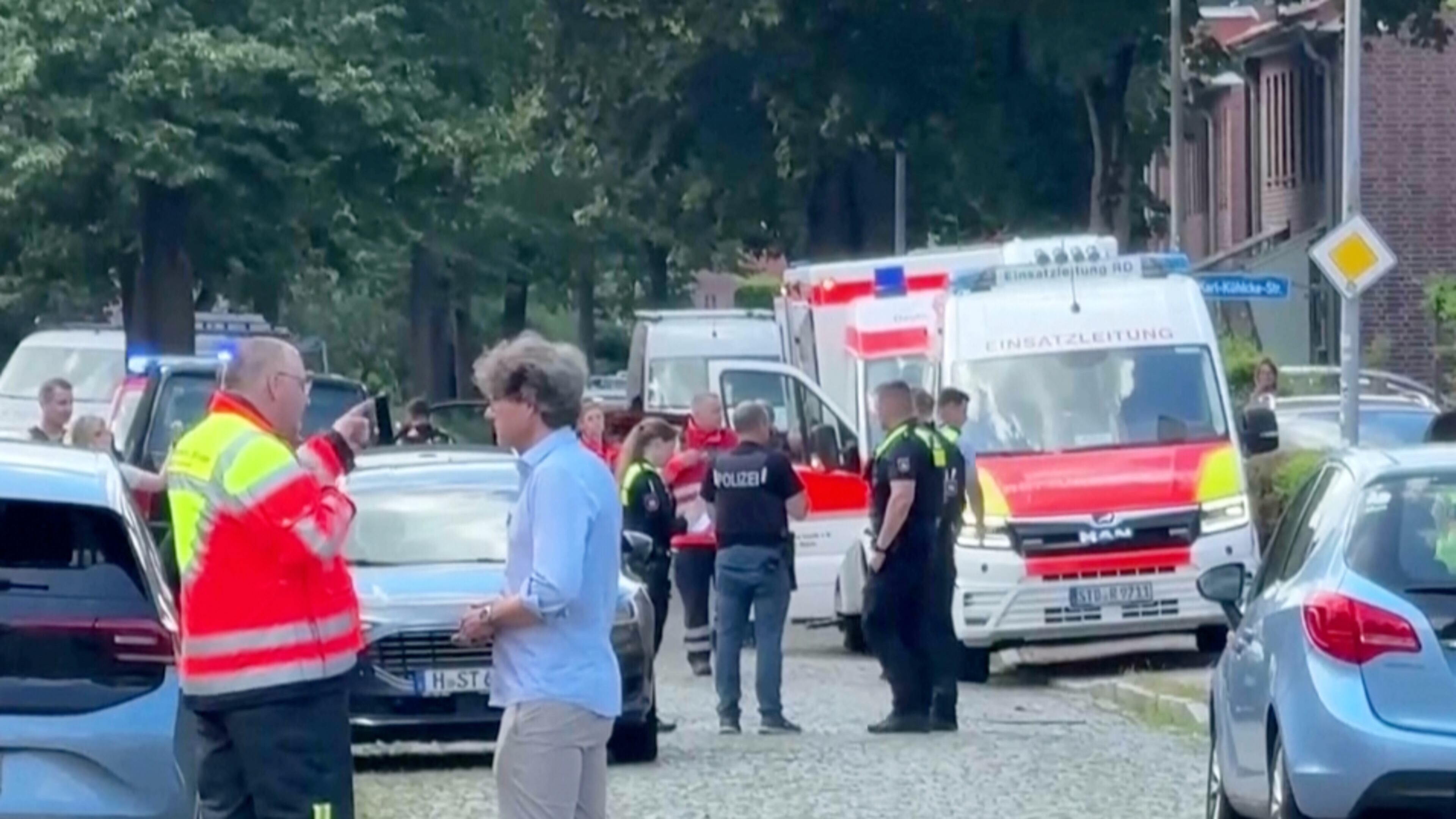 In this image taken from a video, emergency responders, residents and police in Stade, Germany, Monday, June 29, 2026 after five people were killed in a shooting on Monday at a youth welfare facility in the northern German town of Stade, police said. (NWM-TV via AP)