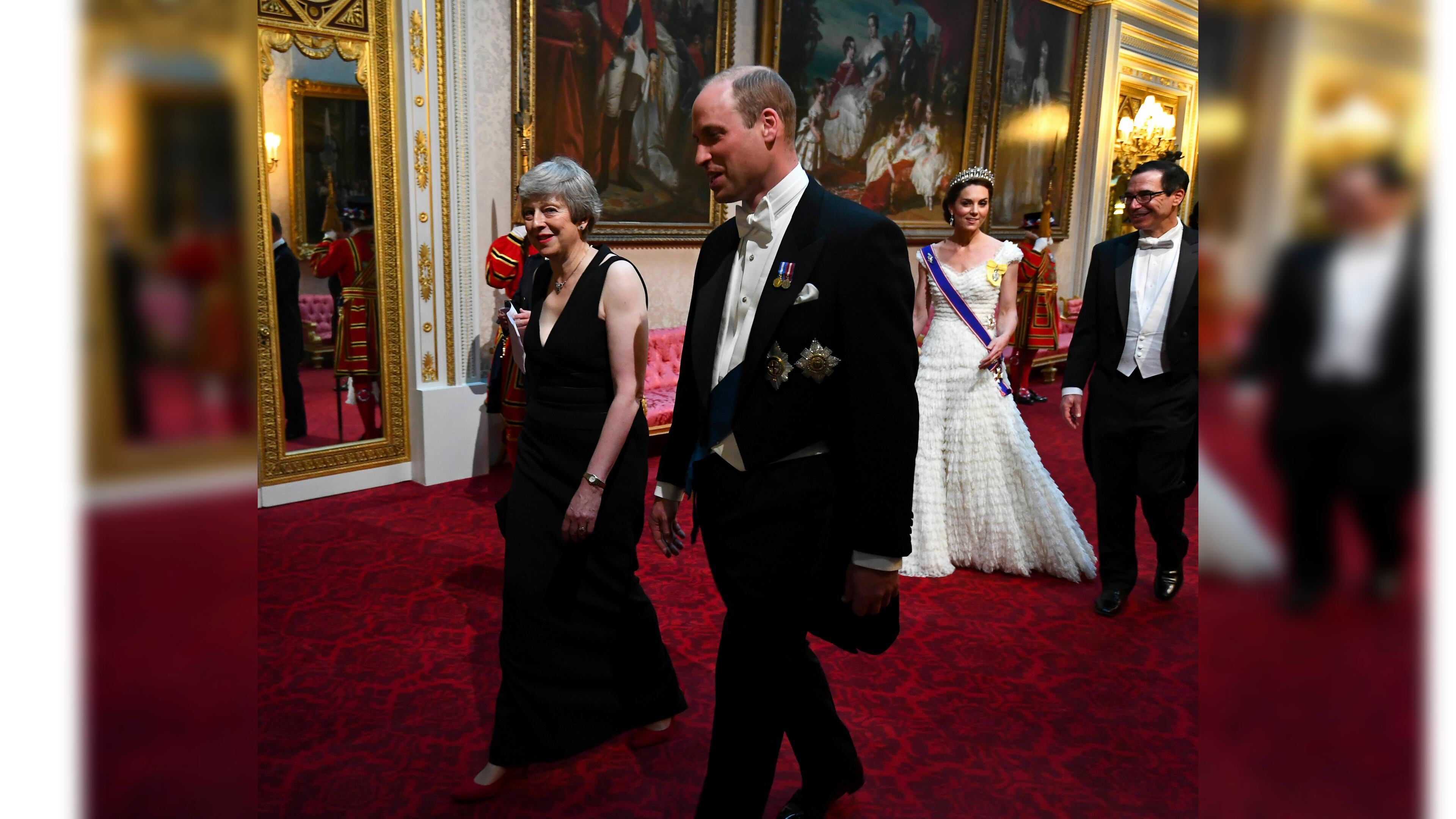 Britain's Prime Minister Theresa May, left, and Prince William, Duke of Cambridge, followed by Kate, the Duchess of Cambridge, and United States Secretary of the Treasury, Steven Mnuchin, arrive through the East Gallery ahead of the state banquet at Buckingham Palace in London, Monday, June 3, 2019. US President, Donald Trump is on a three-day state visit to Britain.