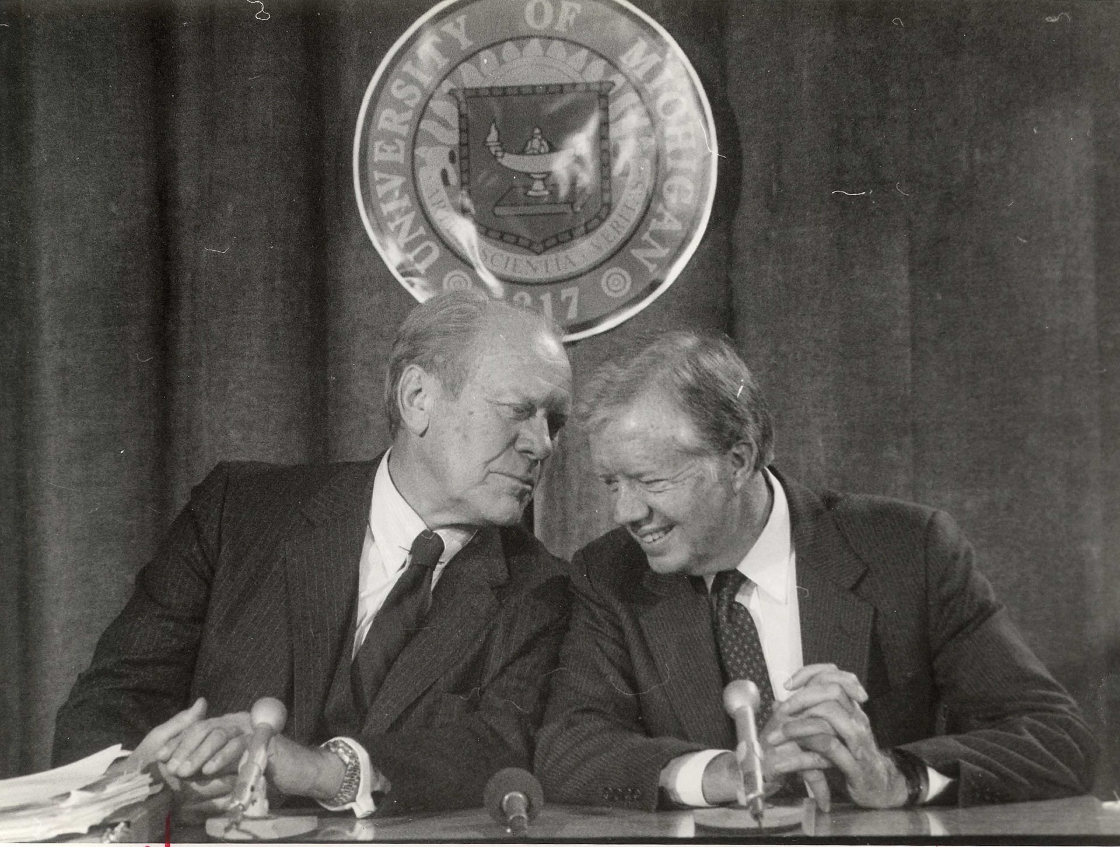 Former U.S. presidents Gerald Ford, left, and Jimmy Carter share a private moment during a symposium on "New Weapons Technologies and Soviet-American Relations" at the University of Michigan in this Nov. 14, 1984, photo in Dearborn, Mich.