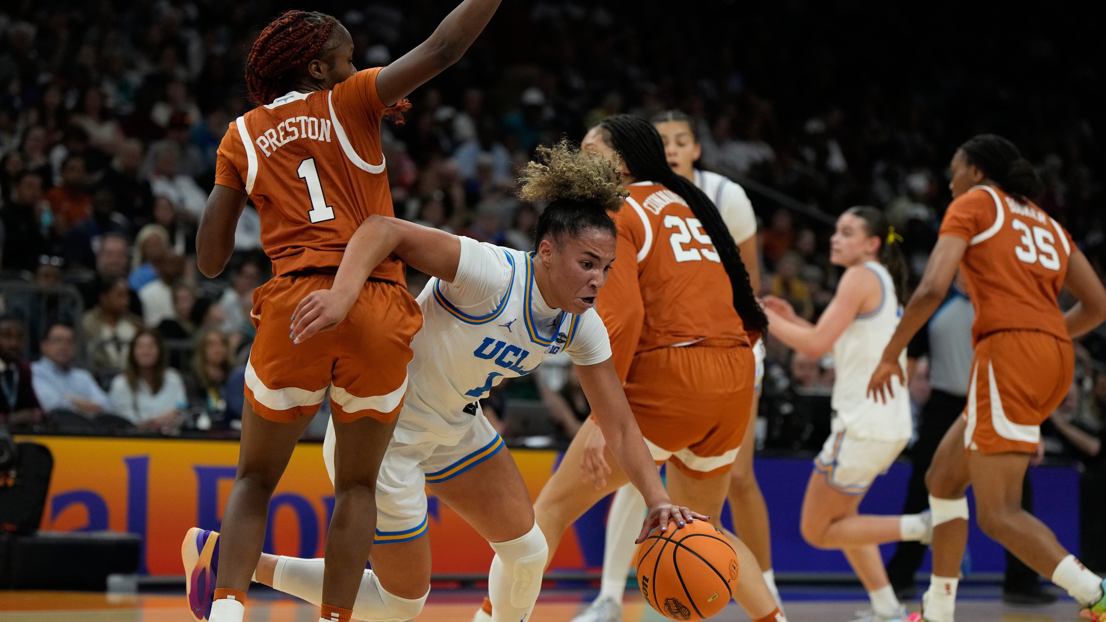 UCLA guard Kiki Rice (1) drives against Texas guard Bryanna Preston, left, during the first half of a women's NCAA college basketball tournament semifinal game at the Final Four, Friday, April 3, 2026, in Phoenix. (AP Photo/Ross D. Franklin)