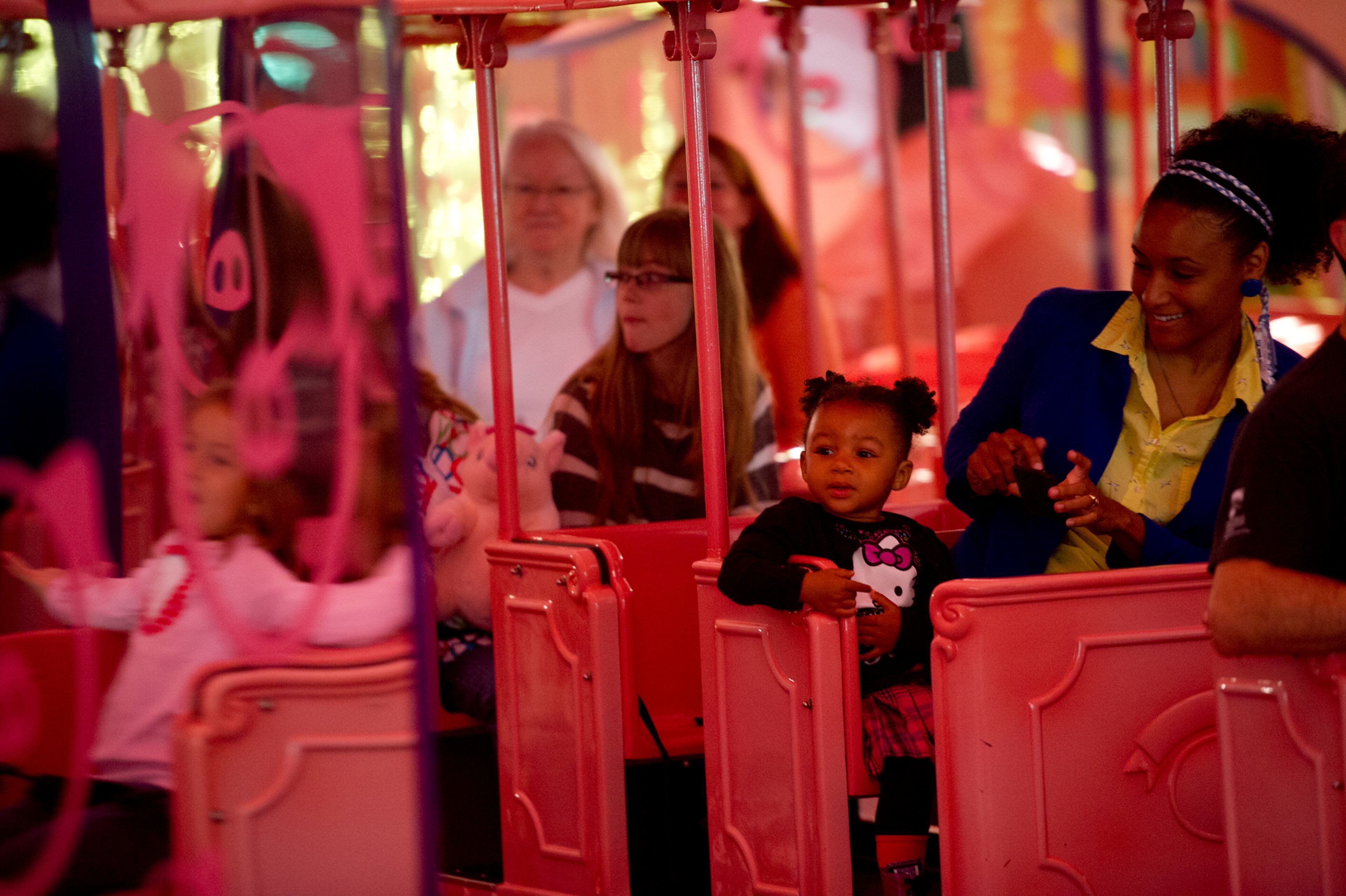 Elle Reeder (left) and her mother Nina ride the Macy's Pink Pig at Lenox Square Mall in Buckhead on Nov. 2, 2013.