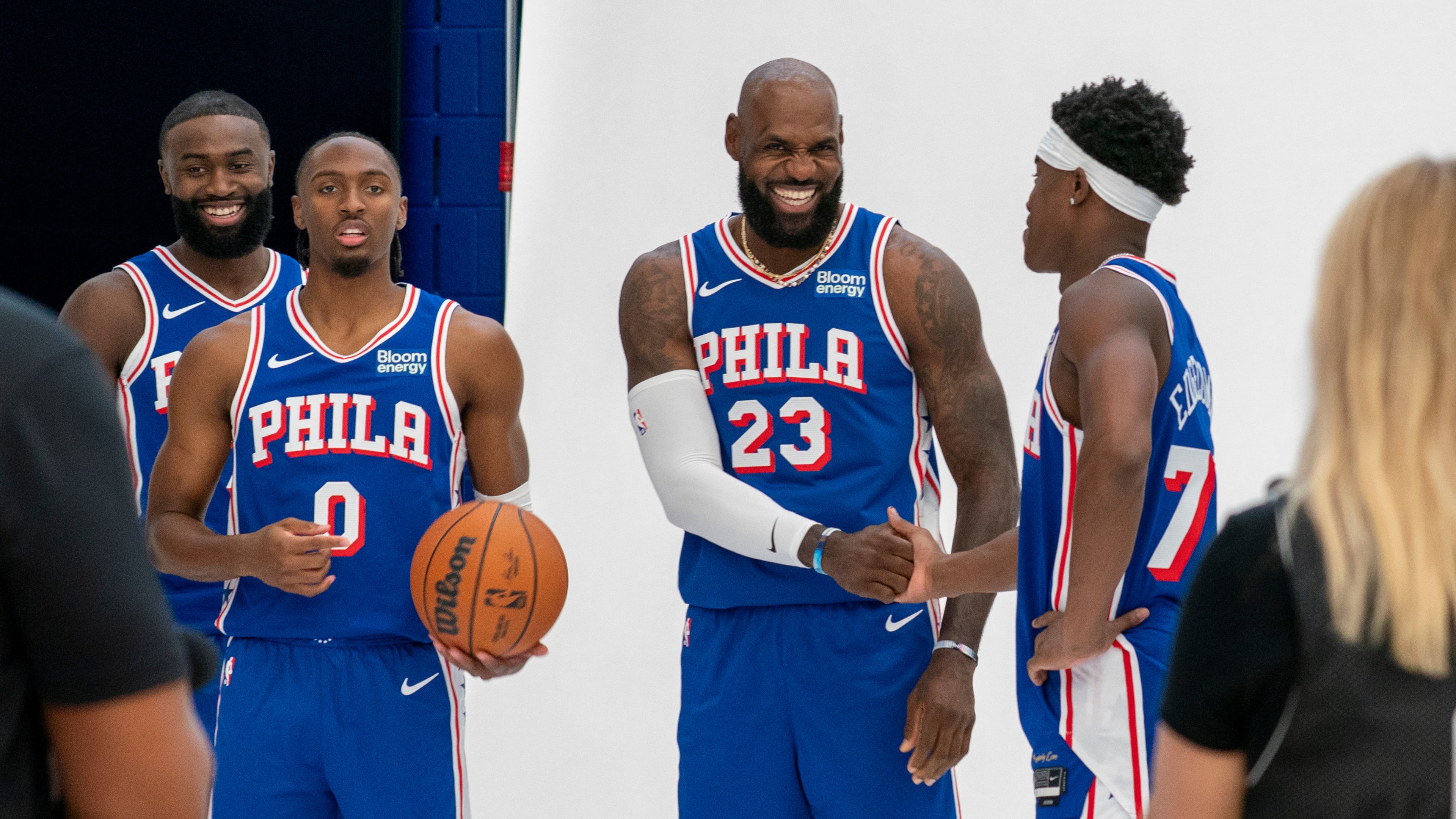 Philadelphia 76ers' LeBron James, center right, greats VJ Edgecombe, right, as they get ready for a group photos with Tyrese Maxey, center left, and Jaylen Brown, left, during the NBA basketball team's media day, Monday, Sept. 28, 2026, in Camden, N.J.. (AP Photo/Chris Szagola)