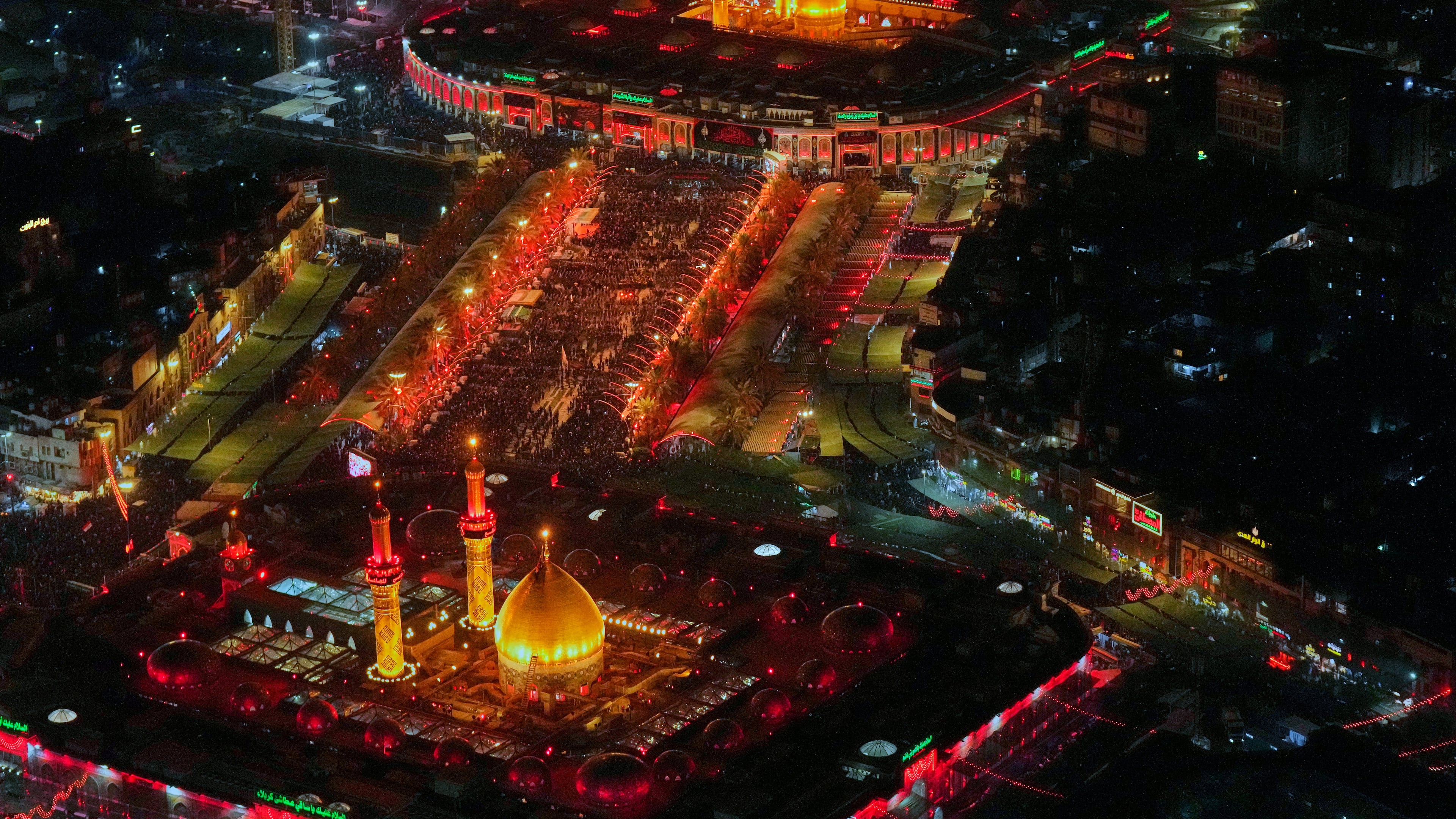 Aerial photo shows Shiite pilgrims gathering between the holy shrine of Imam Hussein and the holy shrine of Imam Abbas ahead of Arbaeen, the annual Shiite commemoration marking 40 days after Ashura, in Karbala, Iraq, Sunday, Aug. 2, 2026. (AP Photo/Hadi Mizban)