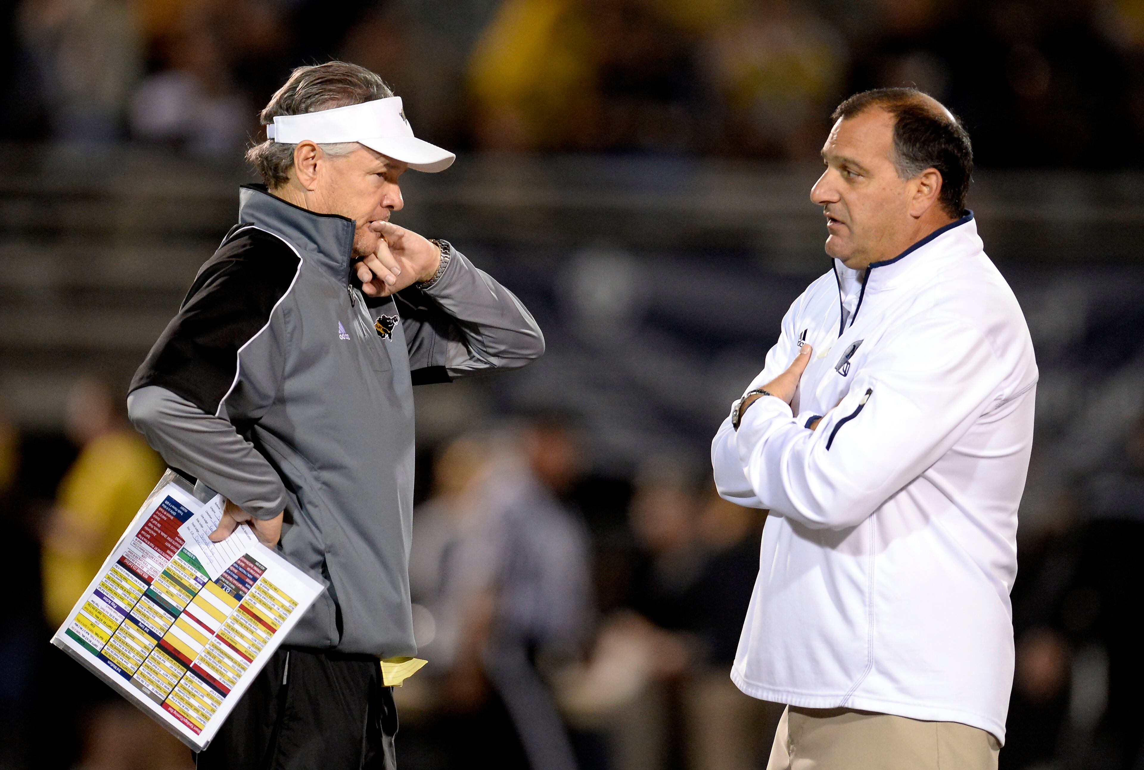 Colquitt coach Rush Propst, left, and Norcross coach Keith Maloof get together at midfield before their AAAAAA semifinal high school football game at Blue Devil Stadium on Friday, Dec. 6, 2013, in Norcross, Ga.
