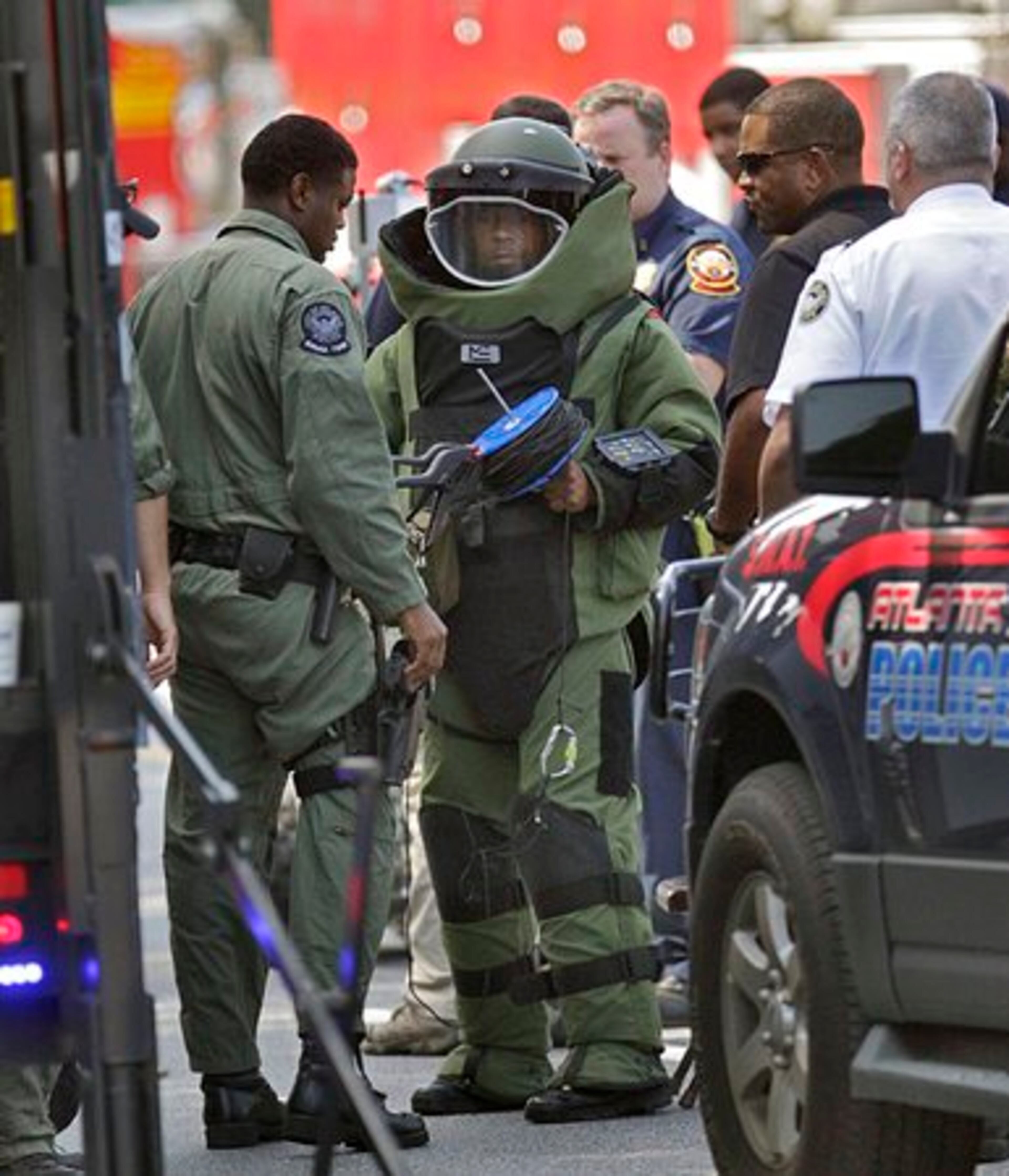 An Atlanta Police bomb-squad officer puts on protective gear before heading to the Wells Fargo bank branch to investigate a suspicious device. Someone reported hearing a ticking sound from the night deposit. Part of Northside Drive was closed by the scare, which lasted most of the morning.