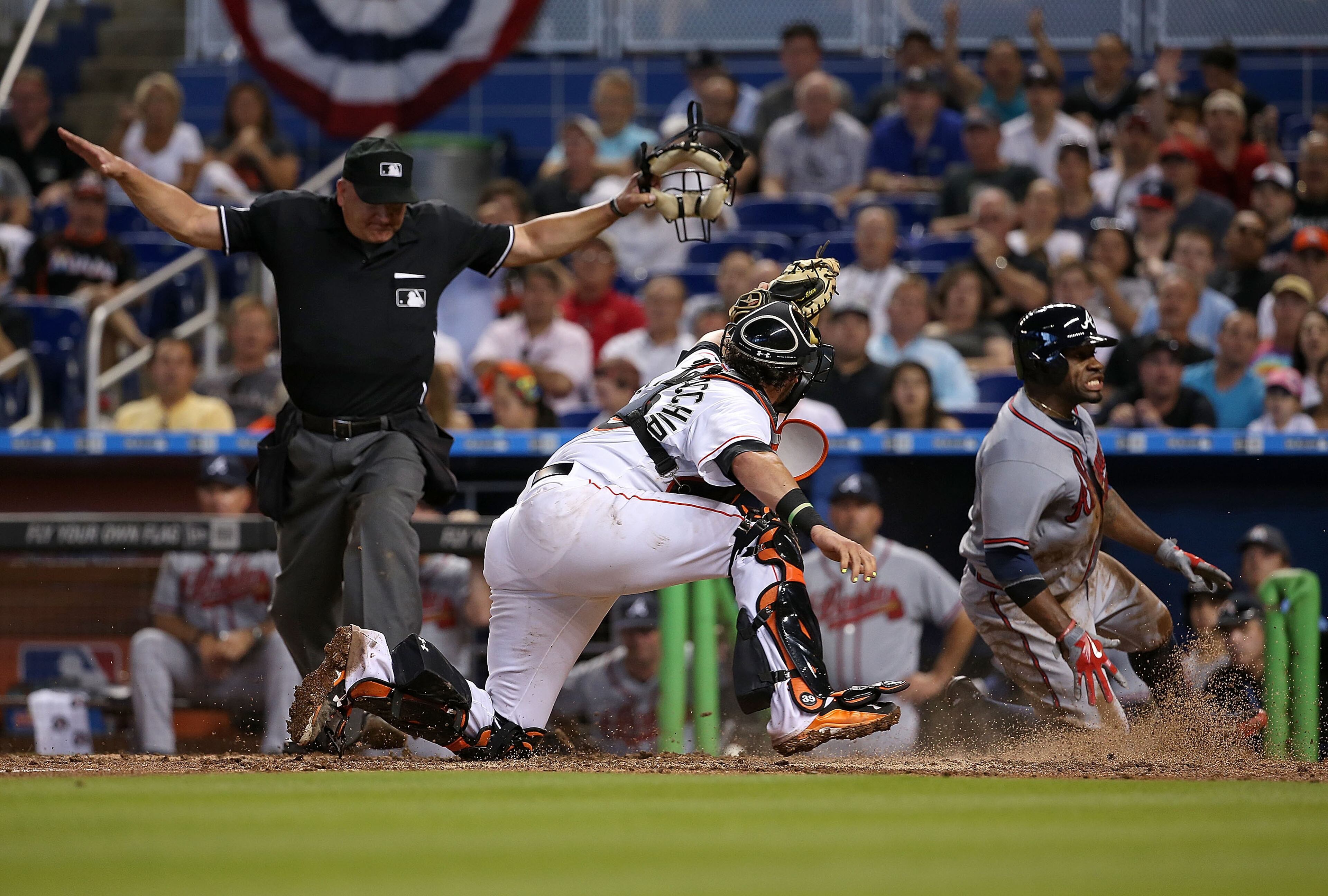 Eric Young Jr. #4 of the Atlanta Braves slides past Jarrod Saltalamacchia #39 of the Miami Marlins to score the go ahead run during Opening Day at Marlins Park on April 6, 2015 in Miami, Florida. (Photo by Mike Ehrmann/Getty Images)