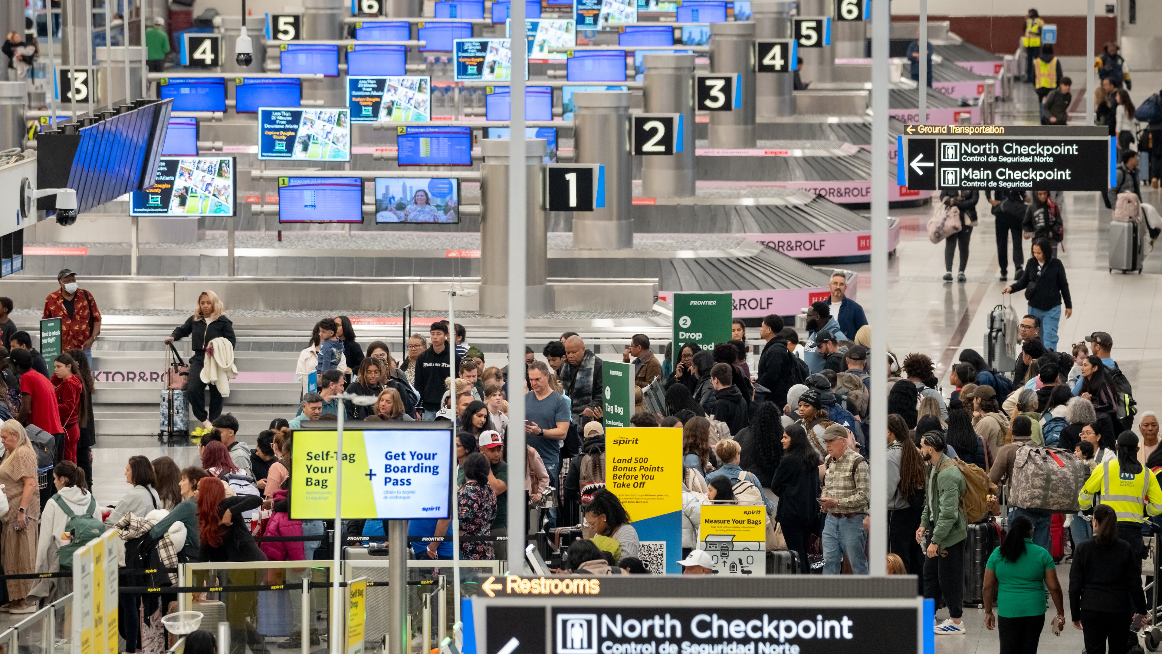 A line of passengers waits at the Frontier Airlines ticketing counter at Hartsfield-Jackson Atlanta International Airport on Friday, Nov. 21, 2025. (Ben Hendren for the AJC)