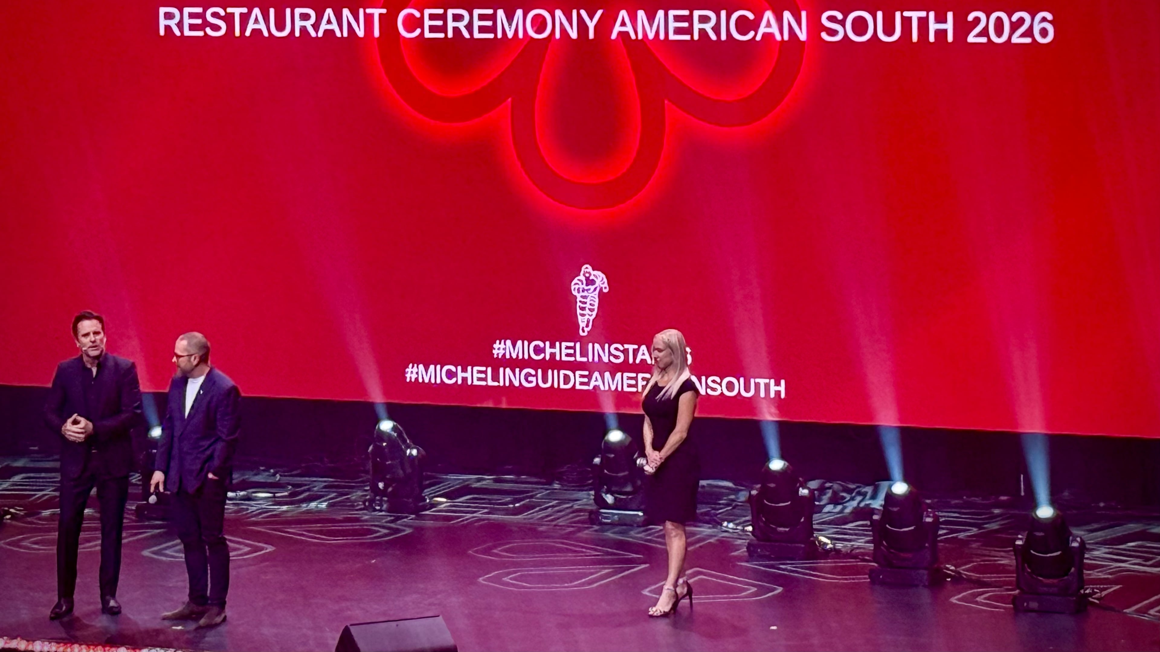 Chef Ryan Smith (second from left) speaks with actor Charles Esten on stage at the 2026 Michelin Guide American South ceremony in Nashville. (Henri Hollis/AJC)