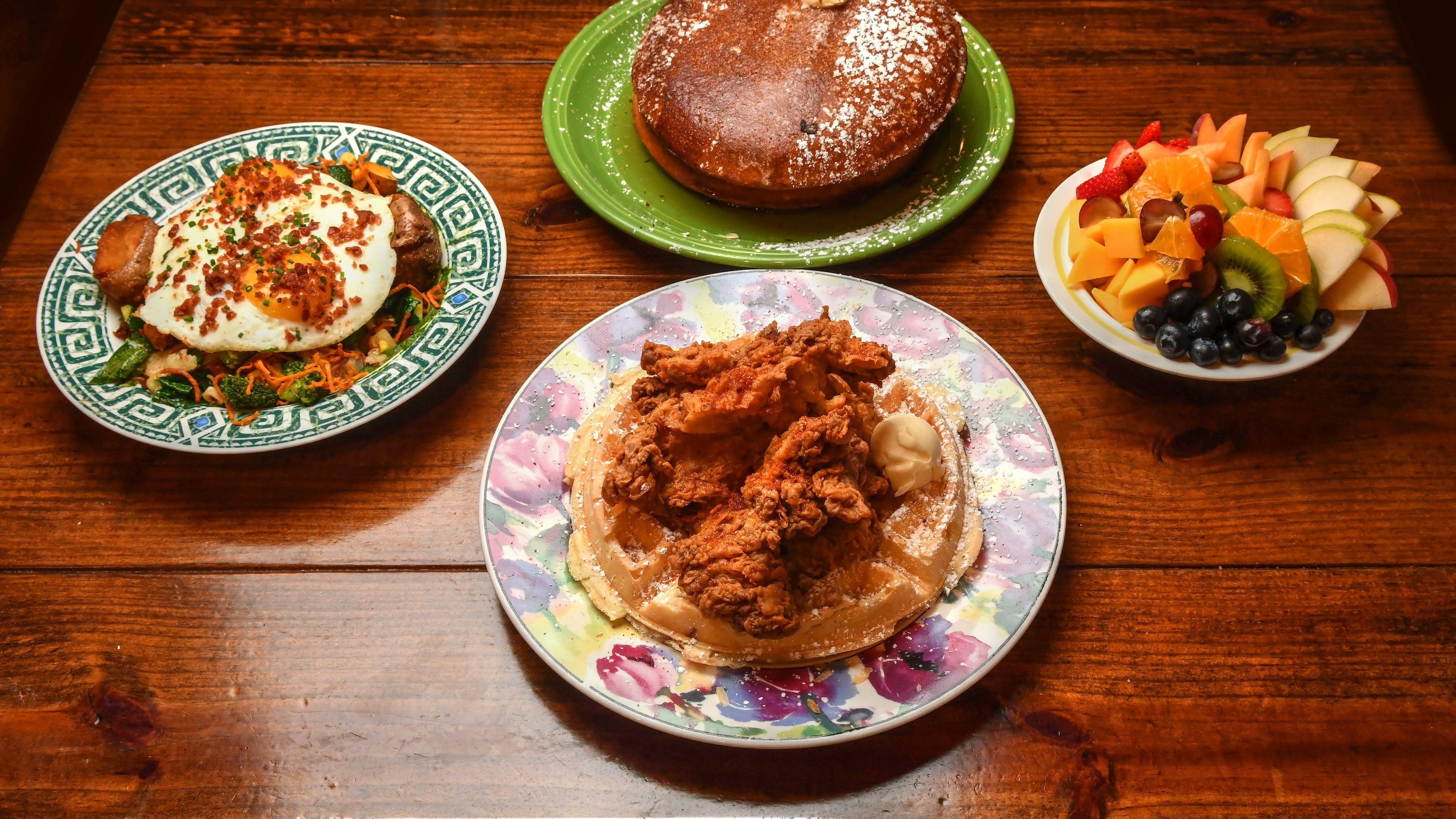 220805 Johns Creek, Ga: Some of the items offered at Hen Mother Cookhouse (from left): Market Hash, Fluffy Buttermilk Pancakes (center top), Chicken & Waffle (center bottom) and Fruit Cup. Photo for Culinary Journey series on Soraya Khoury, co-owner of Hen Mother Cookhouse in Johns Creek, Ga. Photo taken Friday August 5, 2022. AAJC082122SLAATLCULINARYJOURNEY (CHRIS HUNT FOR THE ATLANTA JOURNAL-CONSTITUTION)