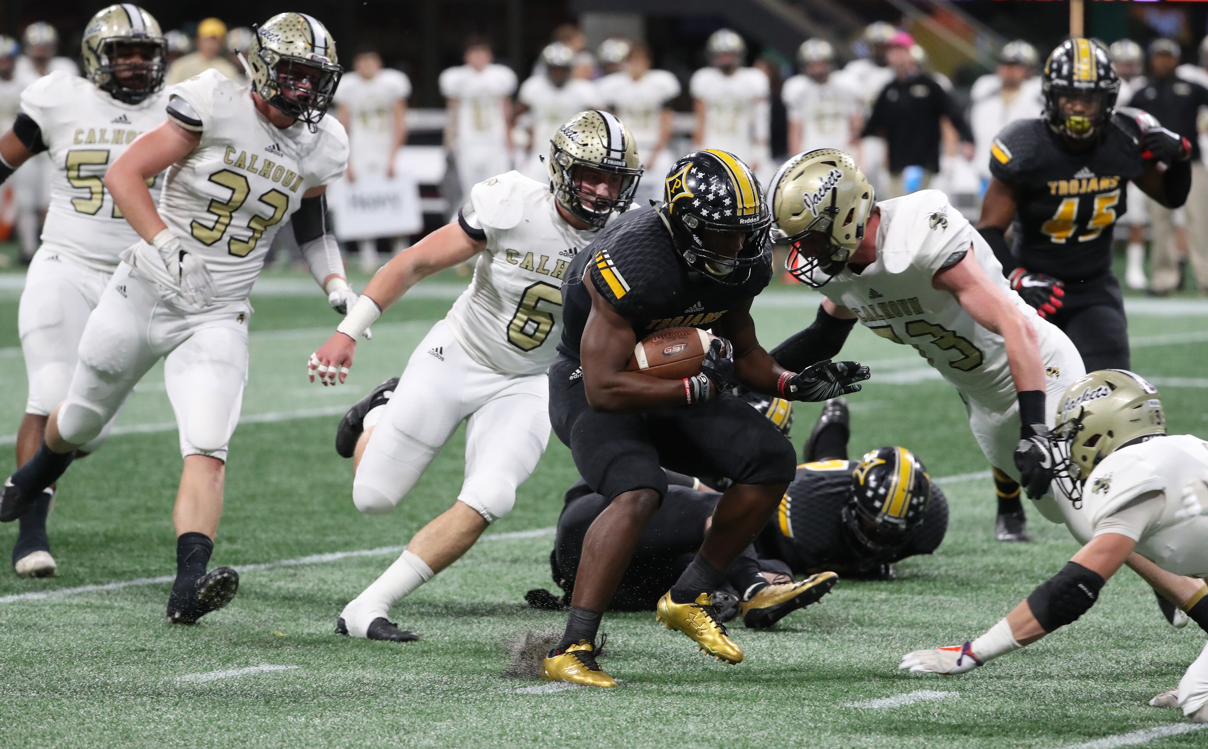 Peach County running back Trevon Woolfolk (9) is stopped by a host of Calhoun defenders in the first half of the Class AAA Championship at Mercedes-Benz Stadium Friday, December 8, 2017, in Atlanta. PHOTO / JASON GETZ