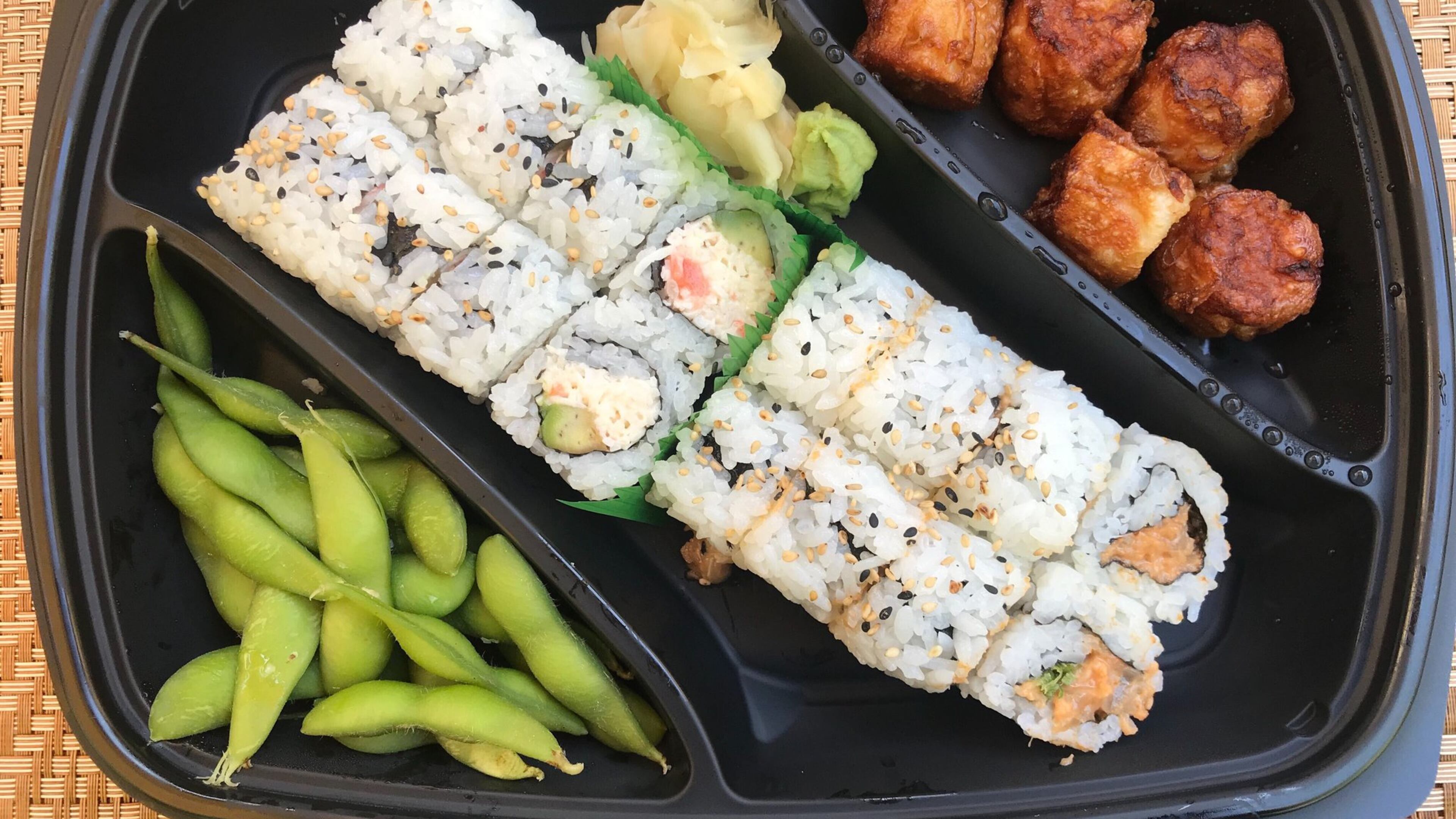 The rice bowl family meal includes four rice bowls along with five fried shumai, edamame, a seafood roll, spicy tuna roll, fried rice and miso soup. Pictured (from left) are the edamame, seafood roll, spicy tuna roll and shumai.