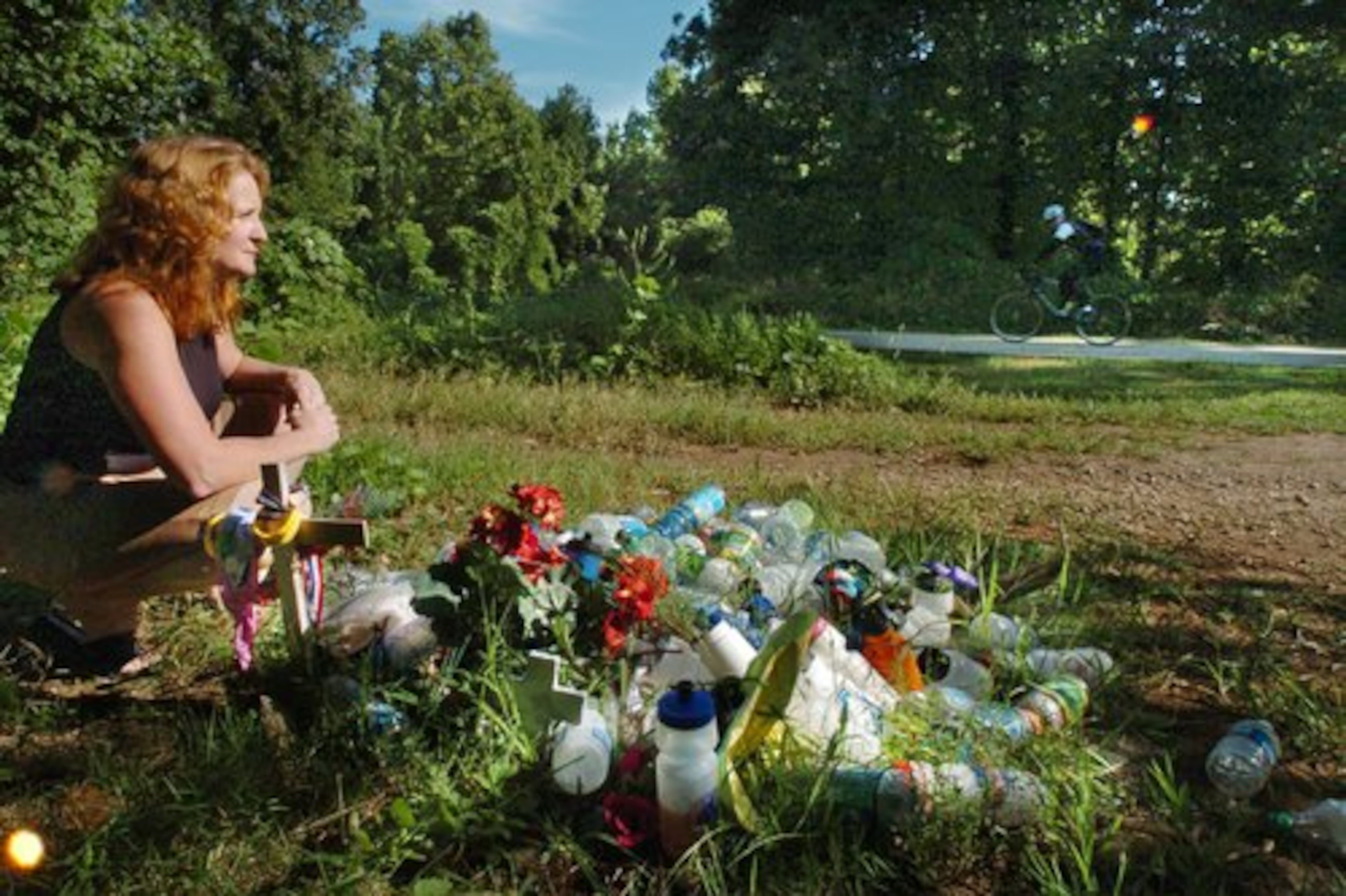 Bernadette Boas sits close to a point on the Silver Comet Trail where Jennifer Ewing died. Since Ewing's death, cyclists and pedestrians have been leaving items near the area as a way of remembering her. Boas is the organizer of the Jenny Ewing Memorial Ride held in September 2006.
