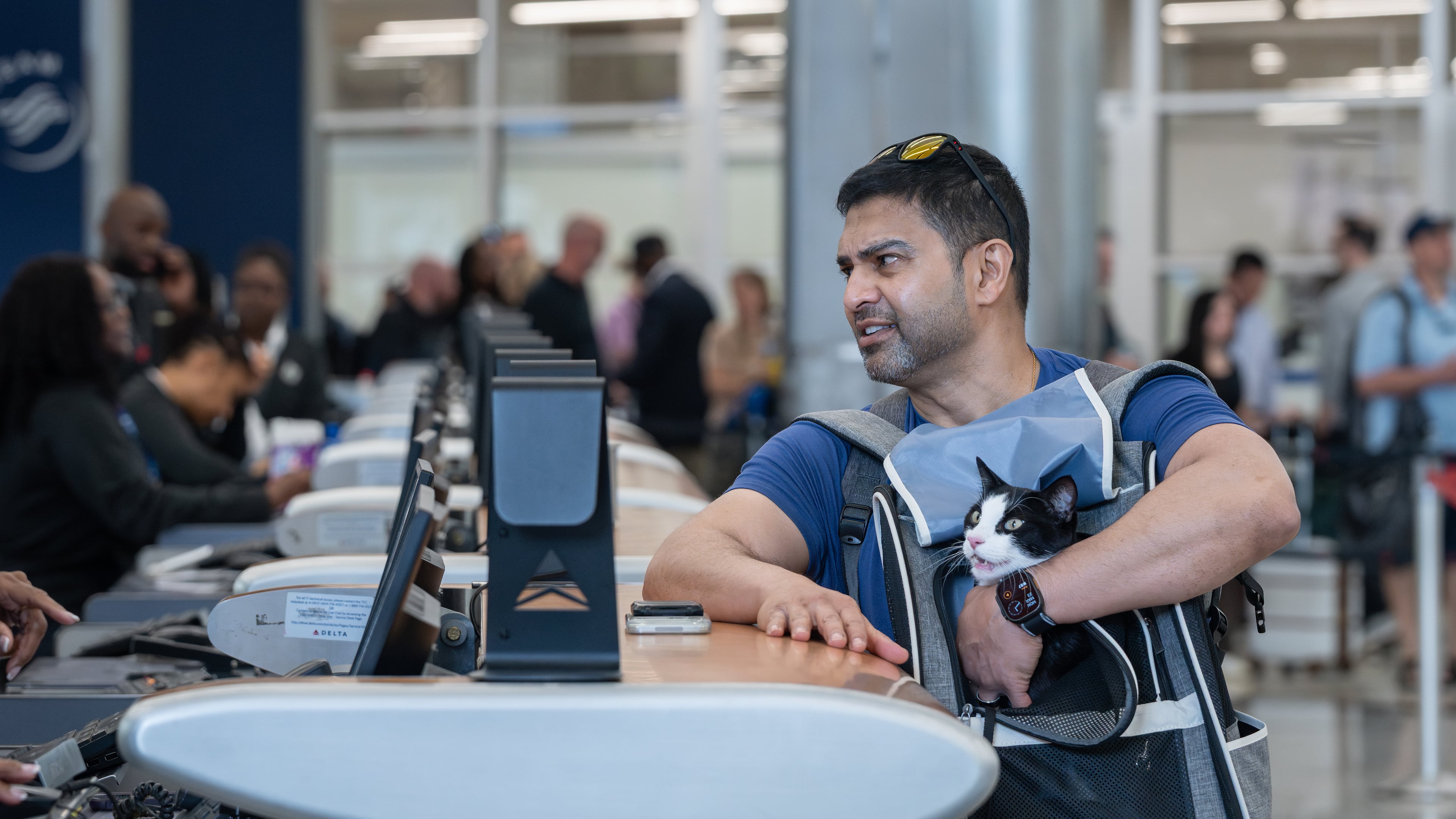 Rj Islam holds his cat Babayaga while checking a bag with Delta Air Lines at Hartsfield-Jackson Atlanta International Airport amid the ongoing partial government shutdown on Monday, March 23, 2026. (Ben Hendren for the AJC)