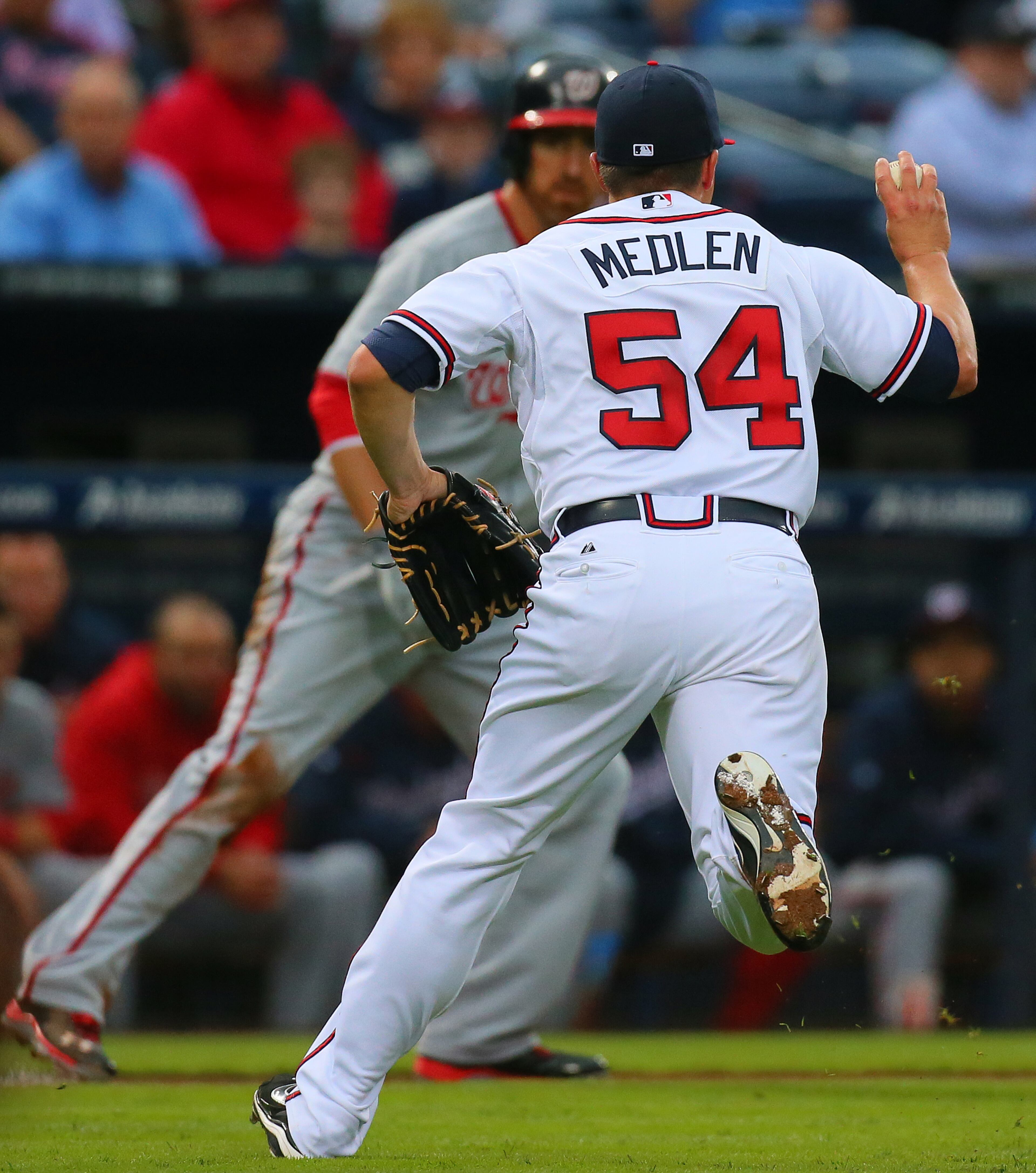 Braves pitcher Kris Medlen throws out Nationals Adam LaRoche in a run-down, catching him between third and home on a ground ball during the second inning.M