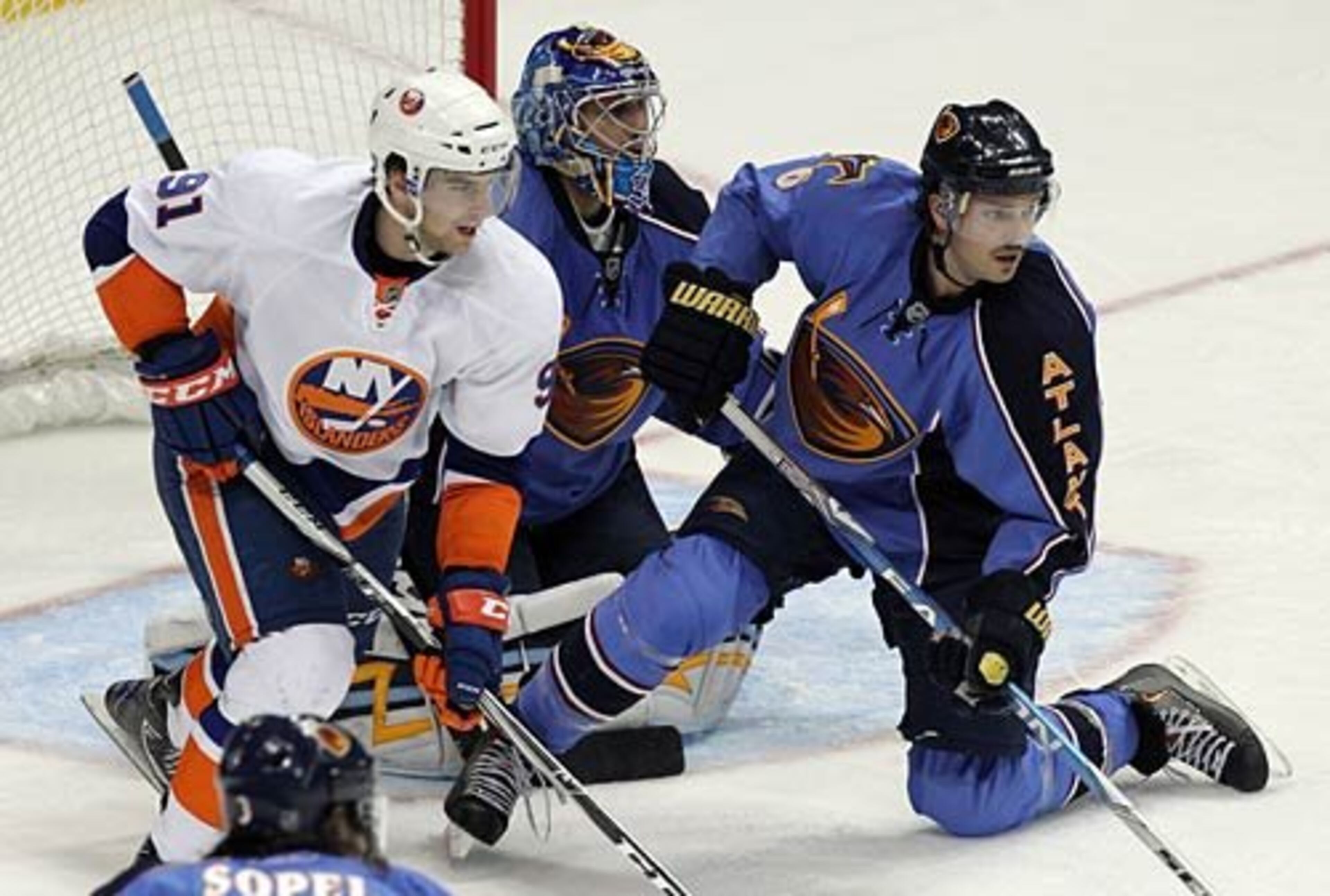 Atlanta's Ron Hainsey helps Thrashers goalie Ondrej Pavelec defend the net against John Tavares and the New York Islanders during 3rd period action.