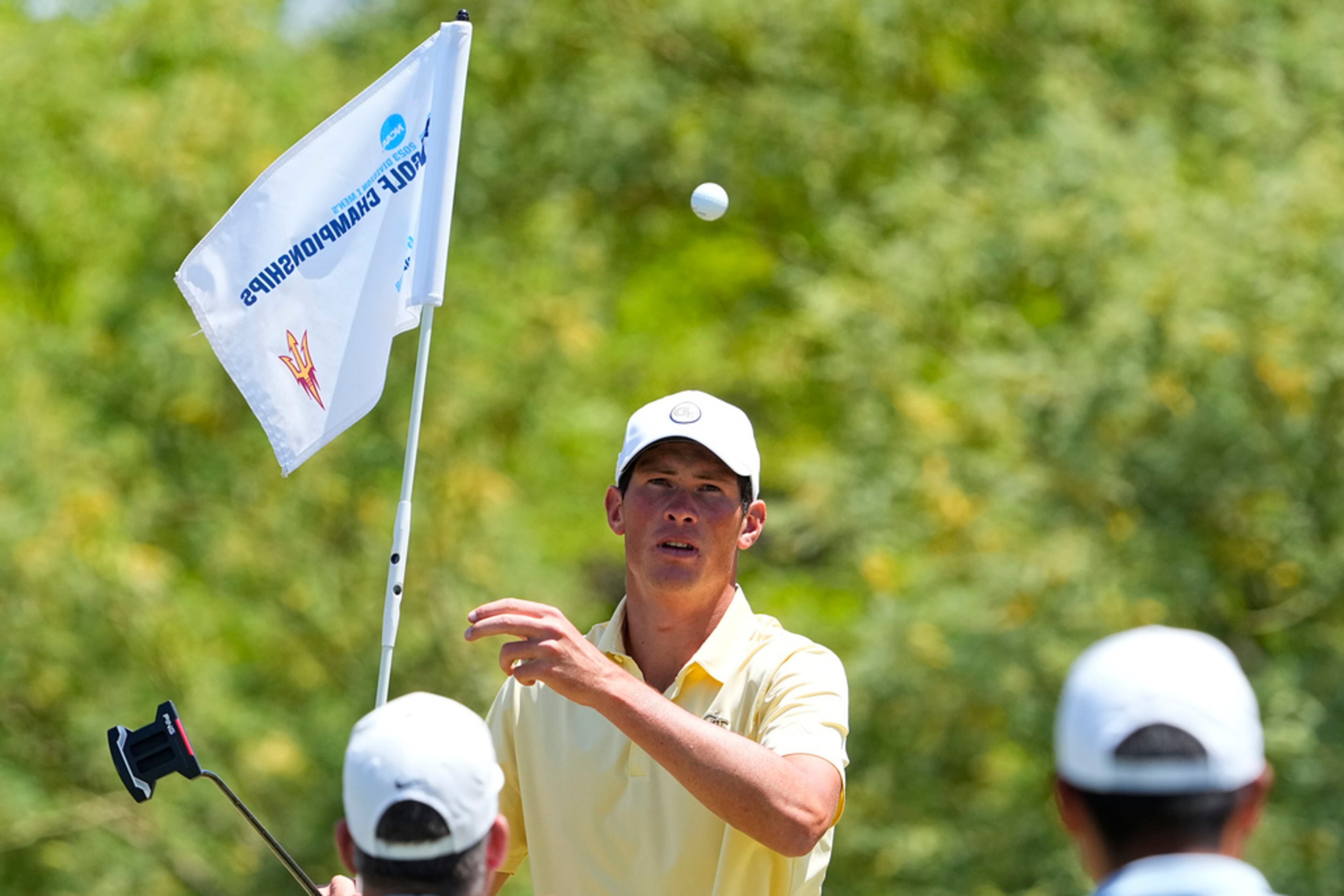 Georgia Tech golfer Christo Lamprecht tosses the ball to Florida golfer Yuxin Lin on the first green during the final round of the NCAA college men's match play golf championship, Wednesday, May 31, 2023, in Scottsdale, Ariz. (AP Photo/Matt York)