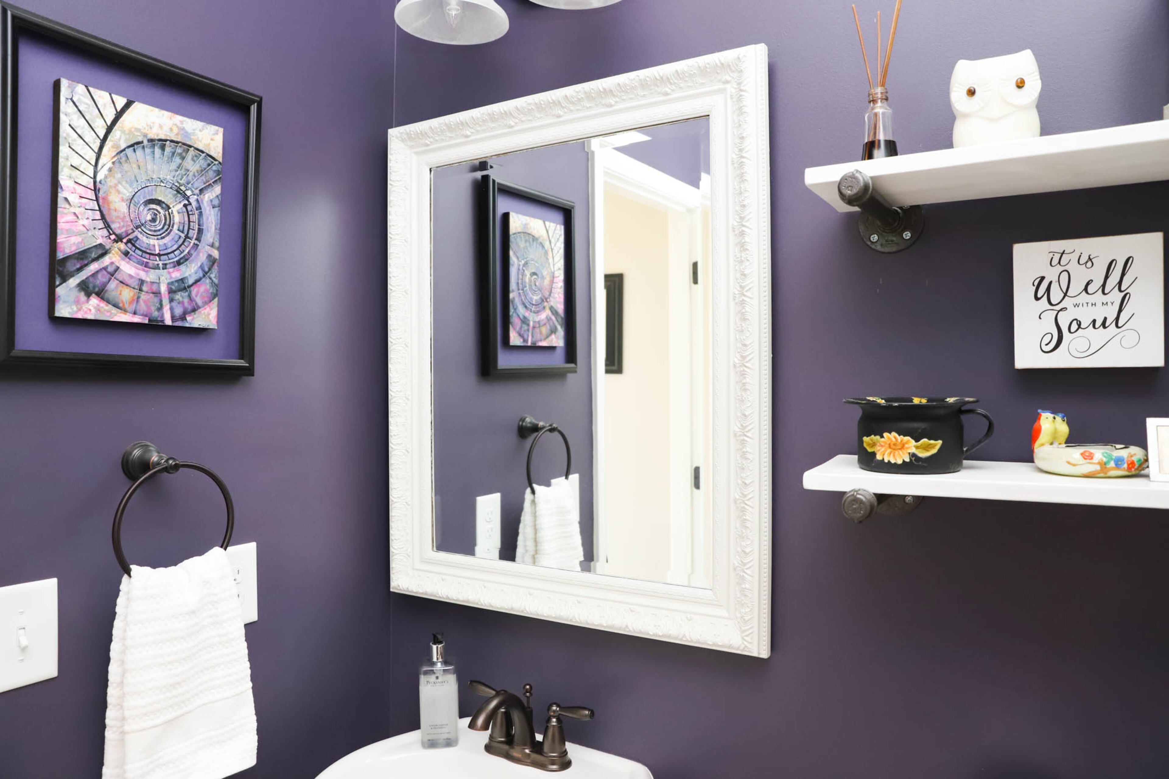 Logan and Brenda Lineberry made the shelves in the half bath of their Roswell home with plumbing fixtures supporting wooden slats painted in Sherwin-Williams Extra White. On the wall hangs a picture of a spiral staircase by an artist in Charleston, South Carolina. Text by Shannon Dominy/Photo by Reynolds Rogers