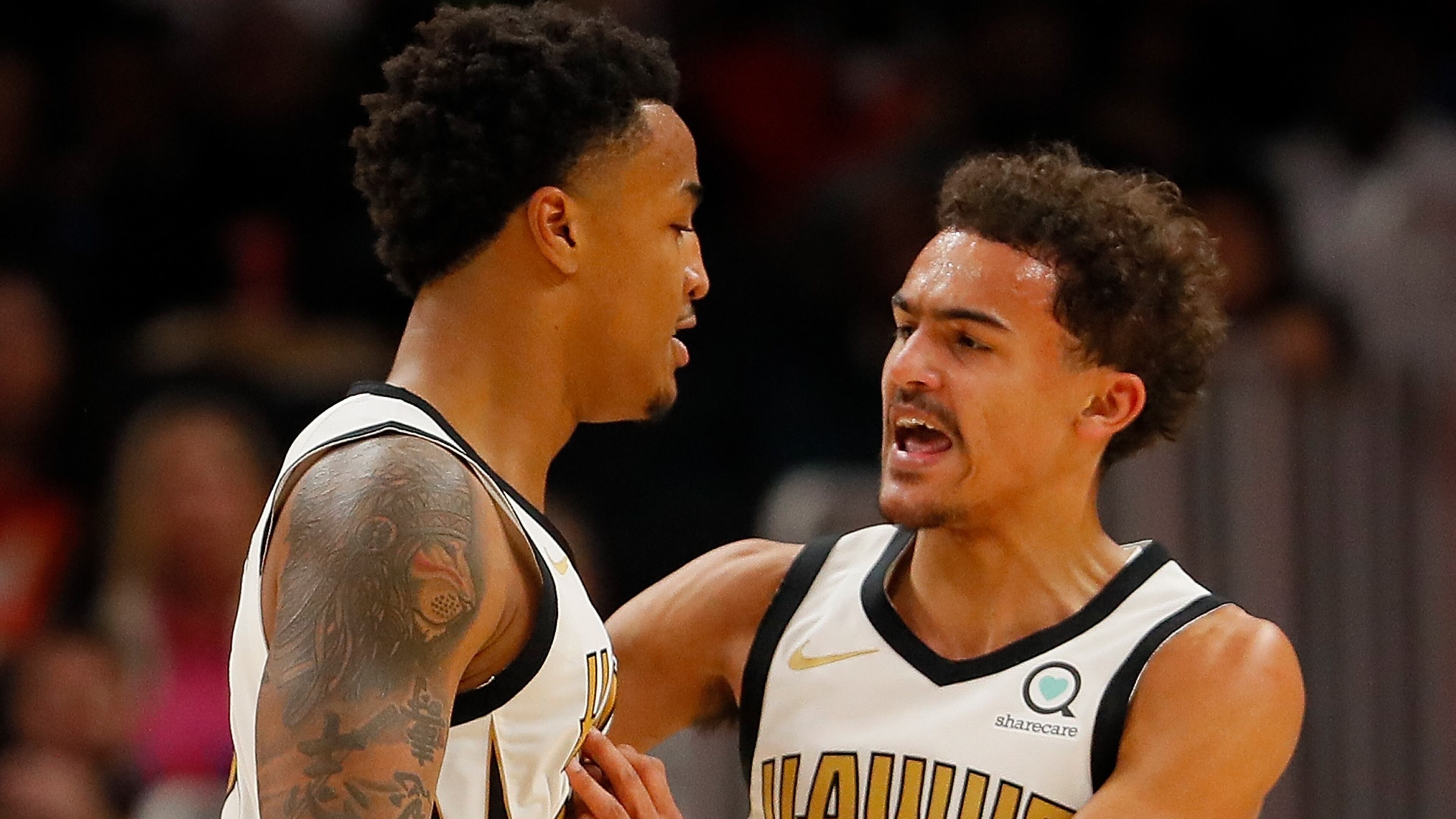 John Collins reacts with Trae Young after dunking against Marcin Gortat of the LA Clippers at State Farm Arena on Nov. 19, 2018 in Atlanta, Georgia.