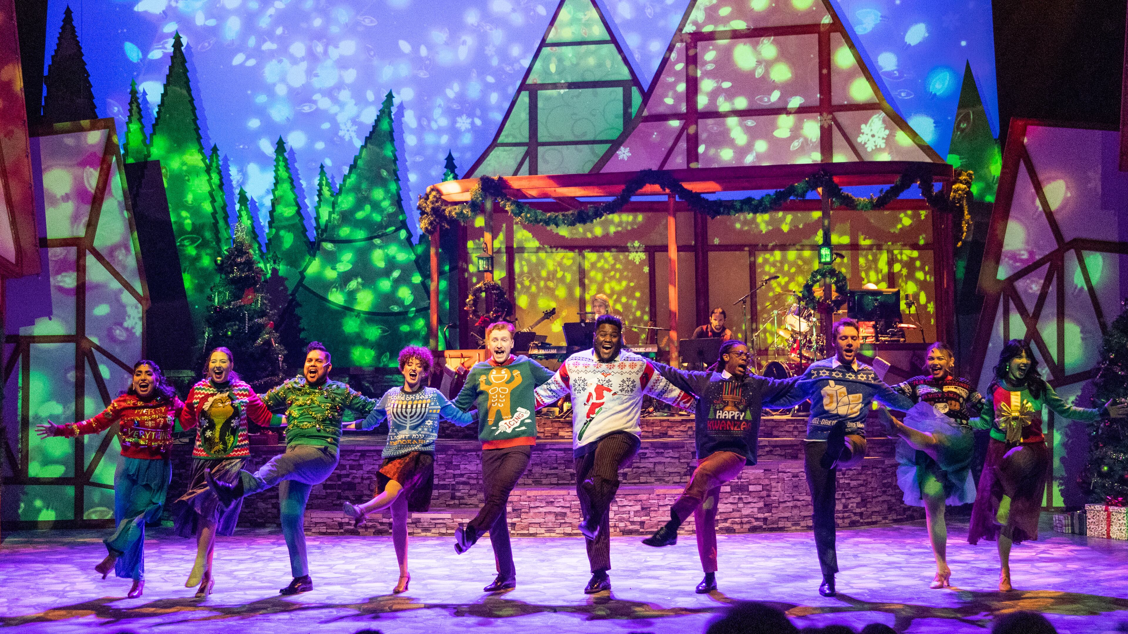 The full cast of “Christmas Canteen” dances wearing holiday sweaters.