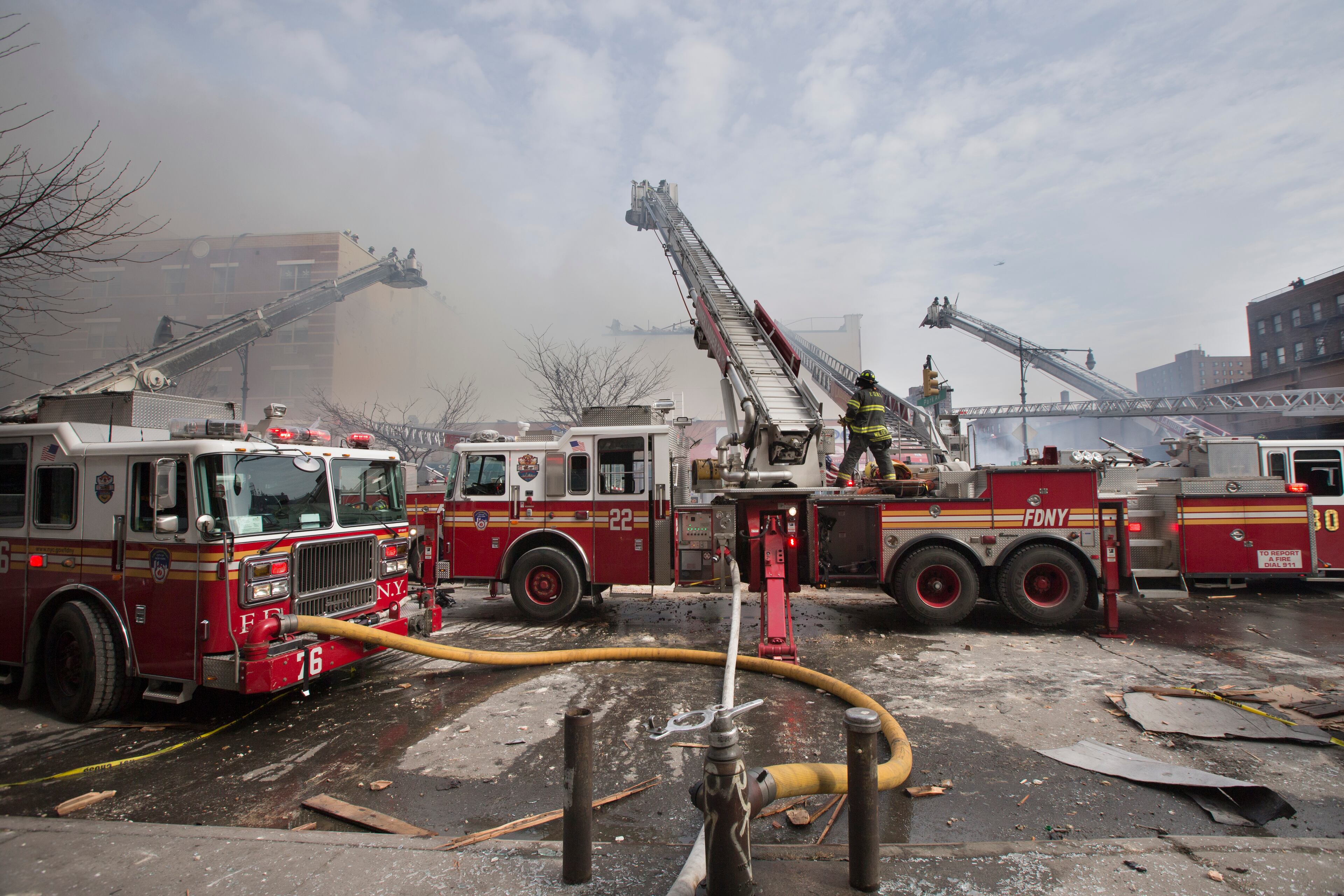 Firefighters respond to a fire after an explosion and building collapse in the East Harlem neighborhood of New York, Wednesday, March 12, 2014. The explosion leveled an apartment building, and sent flames and billowing black smoke above the skyline. (AP Photo/John Minchillo)